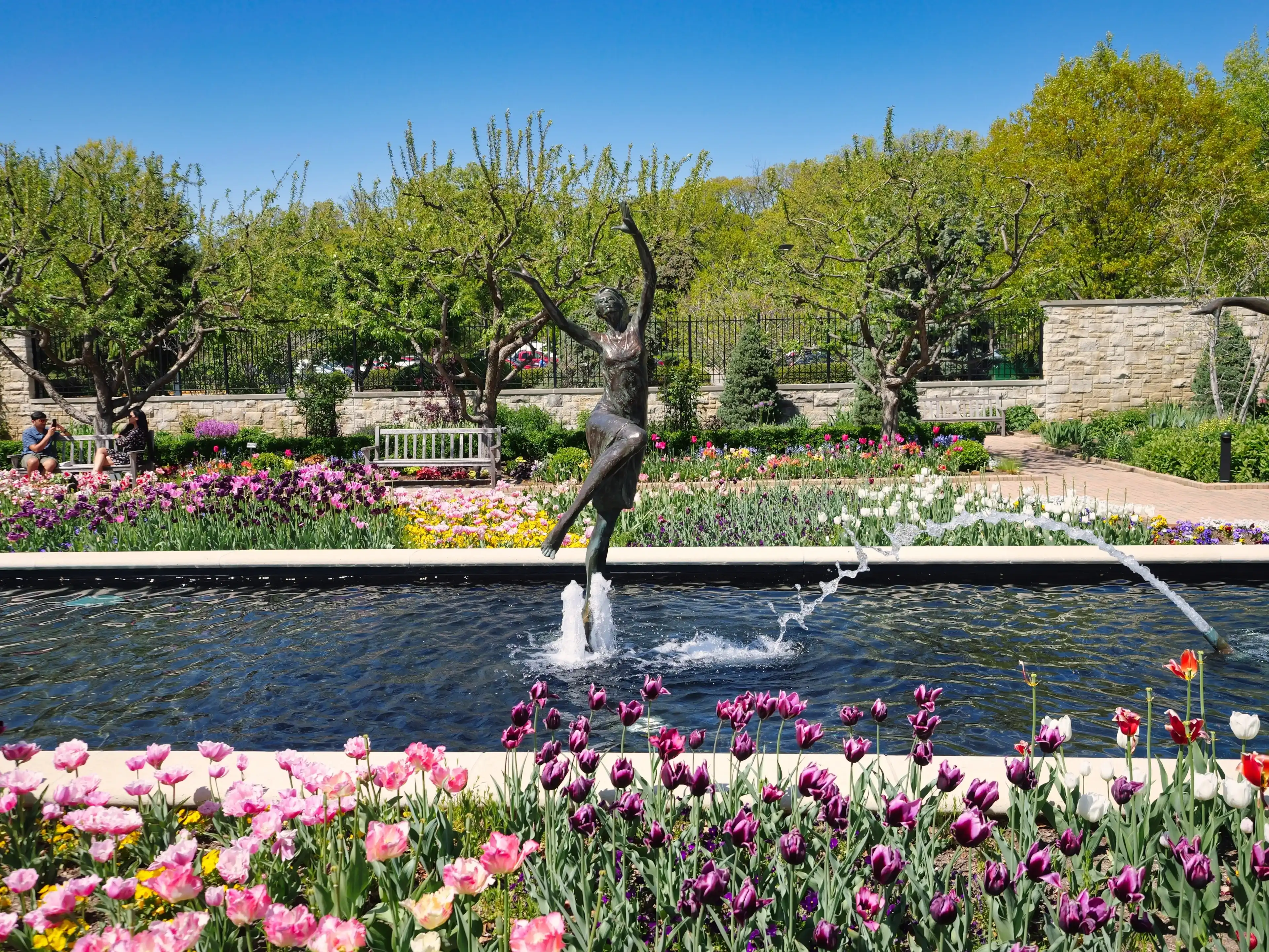 Kansas City, Missouri - April 29, 2023: Female statues in the tulip garden at Kauffman Gardens Kansas City, Missouri - April 29, 2023: Female statues in the tulip garden at Kauffman Gardens