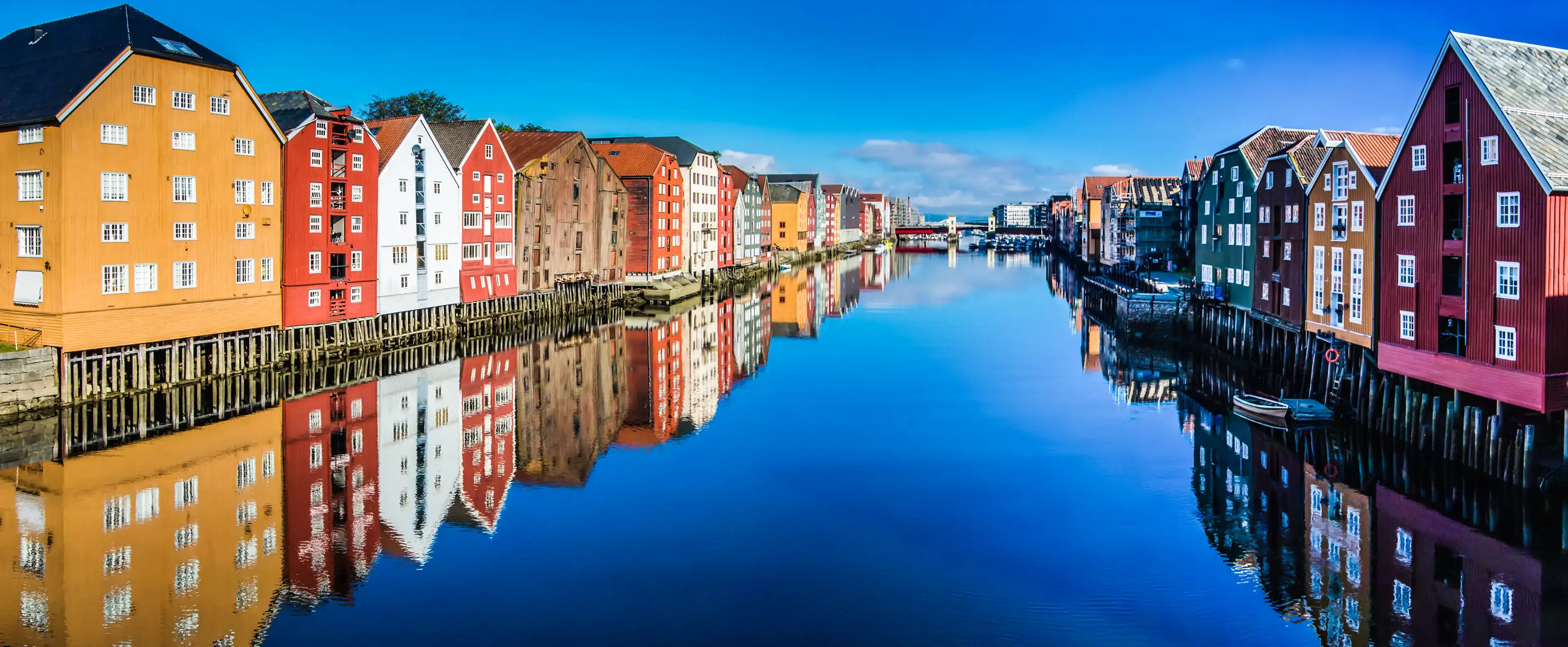 Panoramic view from bridge to famous wooden colored houses in Trondheim city, Norway - architecture background