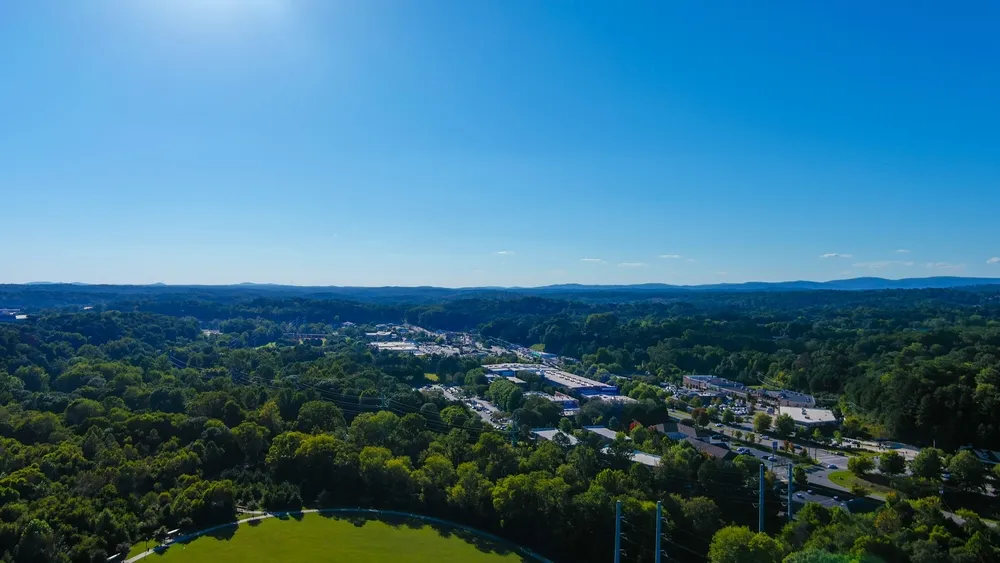 an aerial shot of the vast miles of lush green trees and grass with buildings nestled among the trees and powerful clouds at sunset at Etowah River Park in Canton Georgia USA 