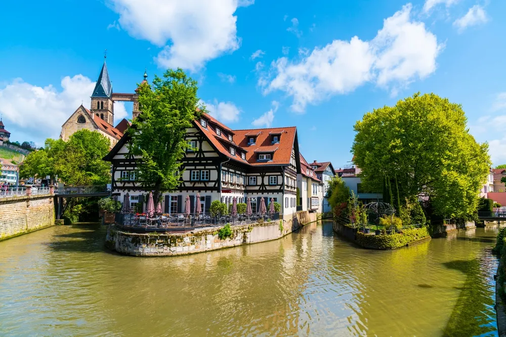 Germany, Old town houses of esslingen am neckar city in summer with blue sky and sun next to neckar river water, a tourism destination