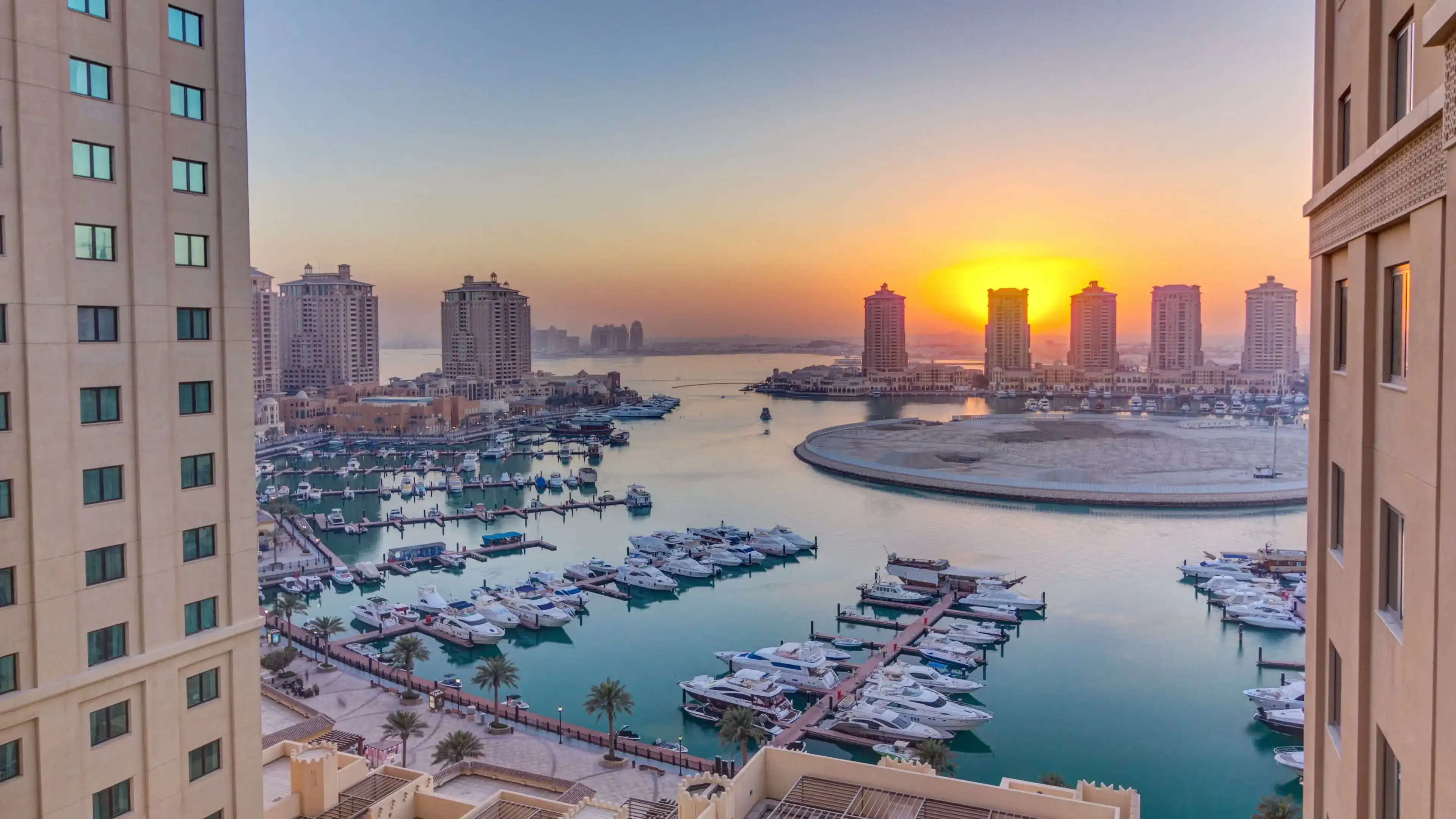 Sunset at the Pearl-Qatar timelapse from top. It is an artificial island in Qatar. View of the Marina and residential buildings in Porto Arabia in Doha, Qatar, Middle East