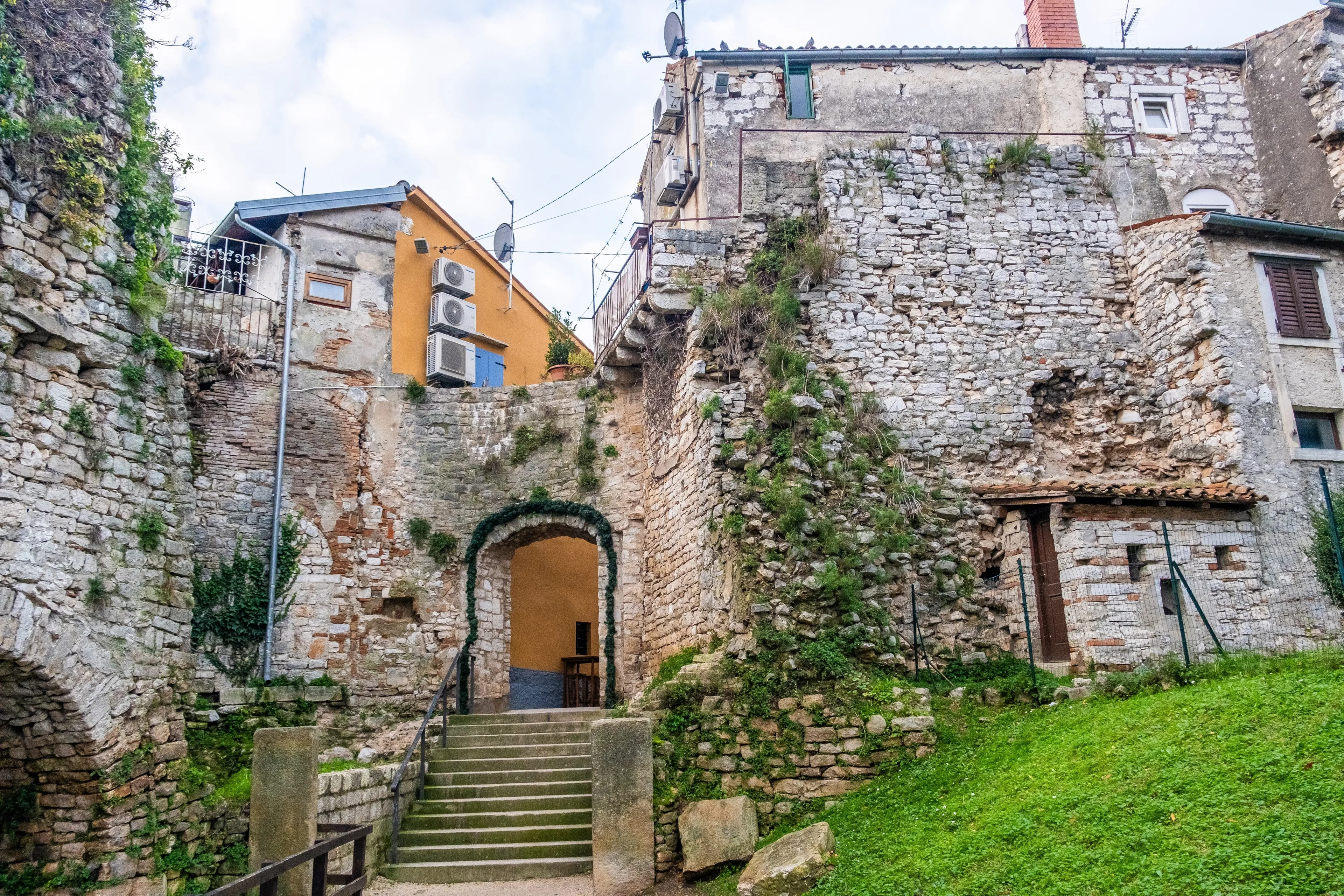 Poreč, Croatia, December 31st, 2023: Historic stone buildings with a charming archway and steps, showcasing the character of Poreč's old town.