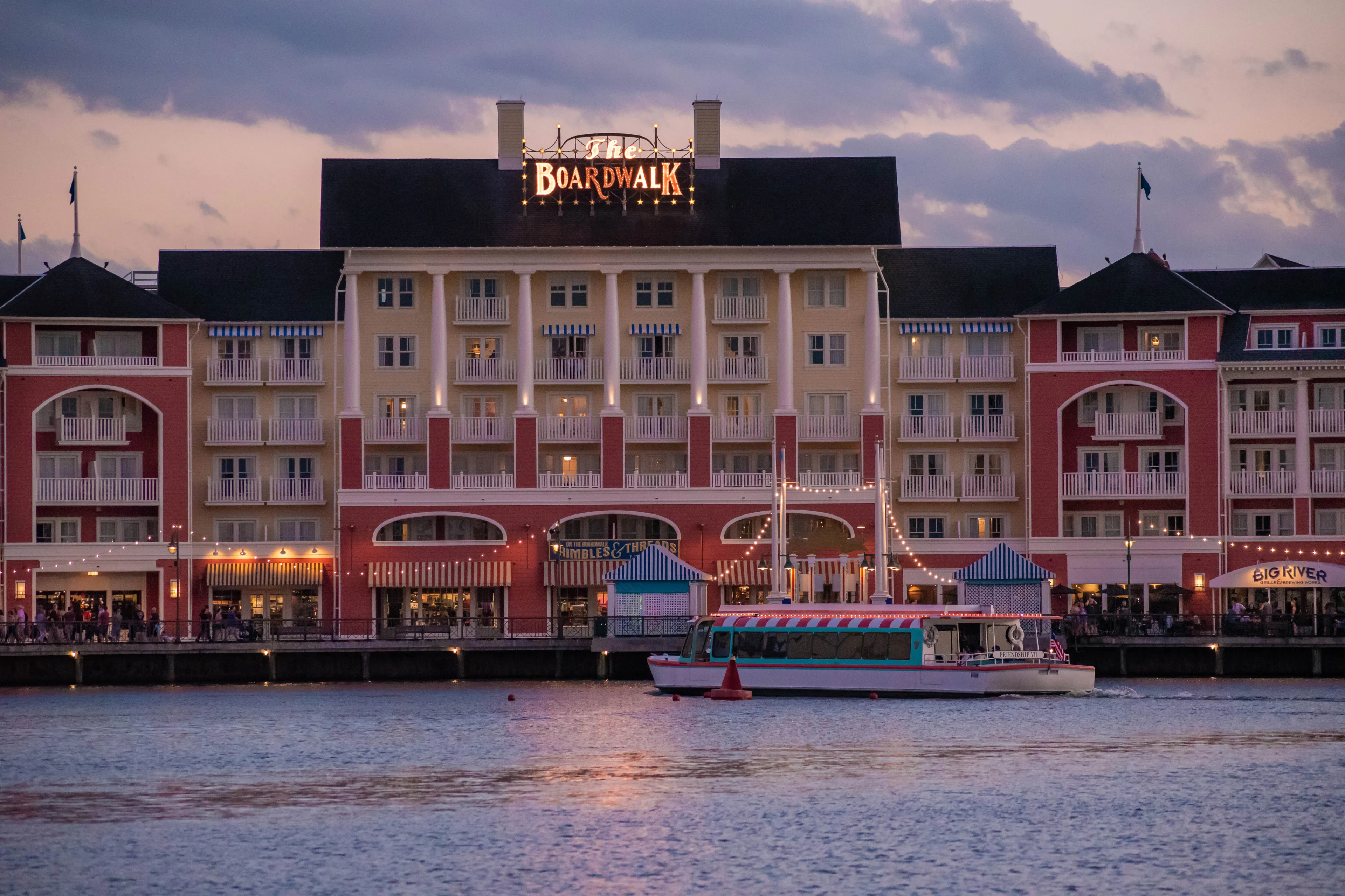 Orlando, Florida. October 11, 2019. Taxiboat sailing on blue lake on colorful buildings background at Lake Buena Vista 2