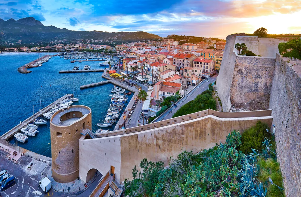 View from the walls of the citadel of Calvi on the old town with historic buildings at evening sunset.Bay with yachts and boats. Luxurious marina and very popular tourist destination. Corsica, France 