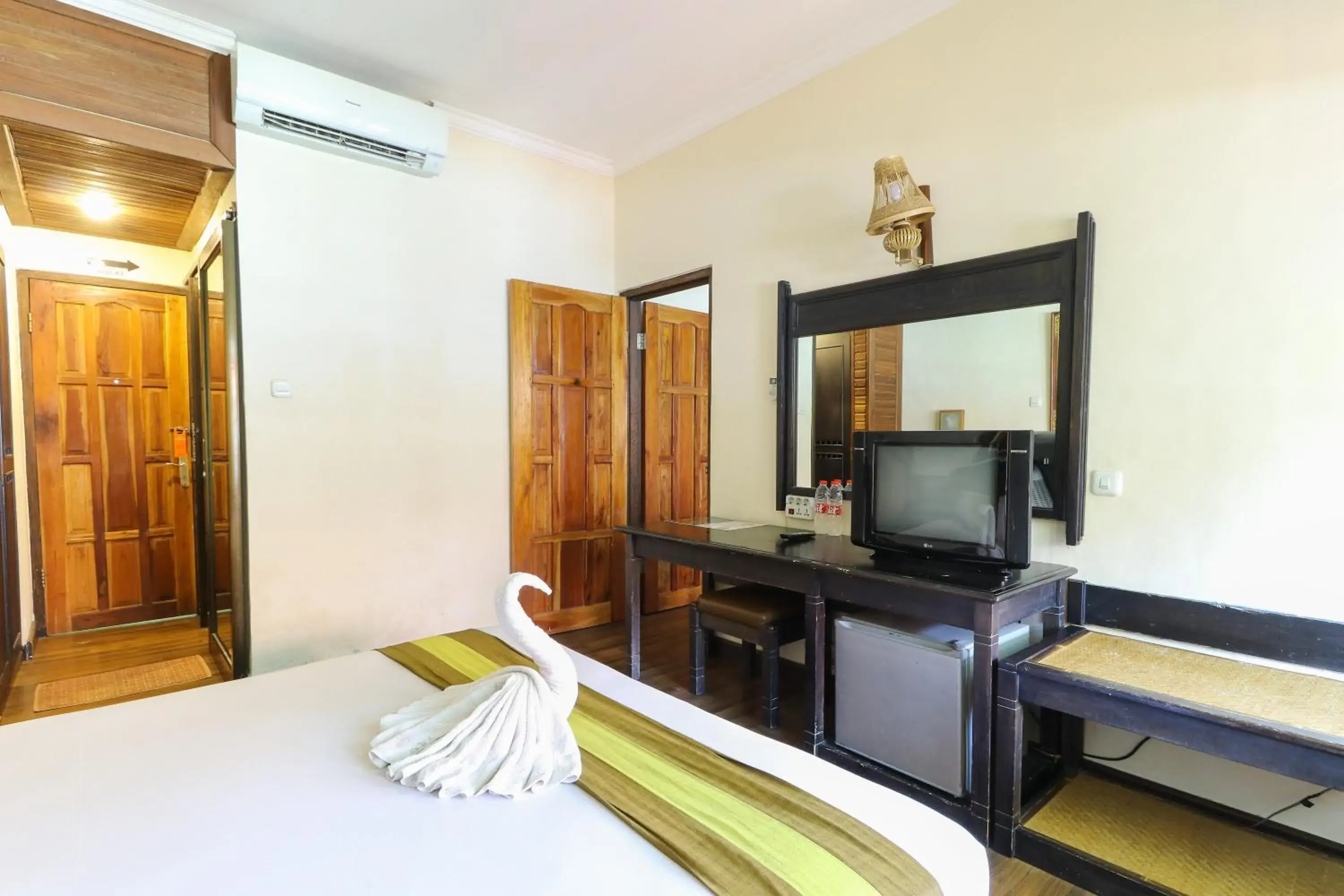 Bed, TV/Entertainment Center in The Flora Kuta Bali Hotel