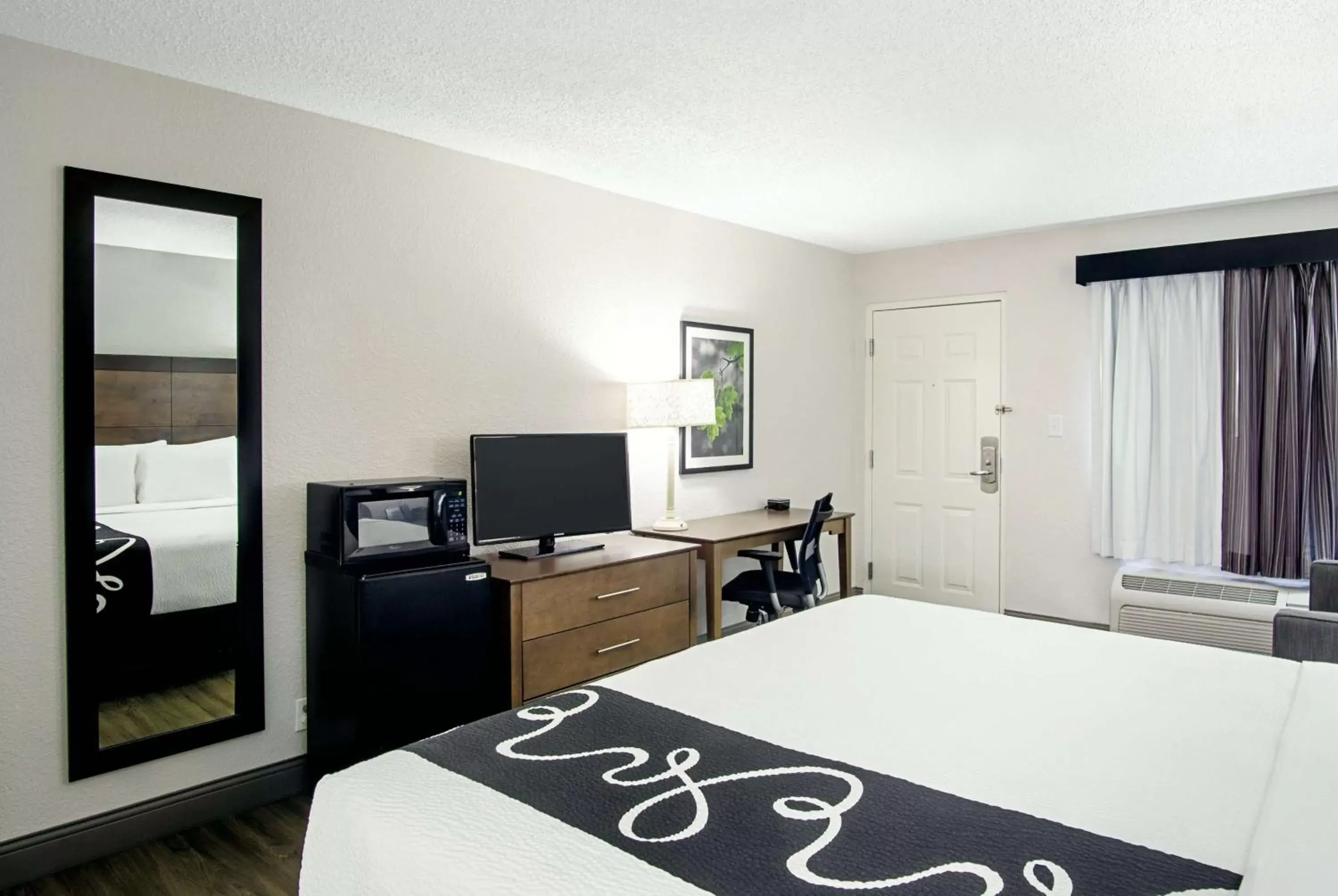 Photo of the whole room, TV/Entertainment Center in La Quinta Inn by Wyndham West Palm Beach - Florida Turnpike