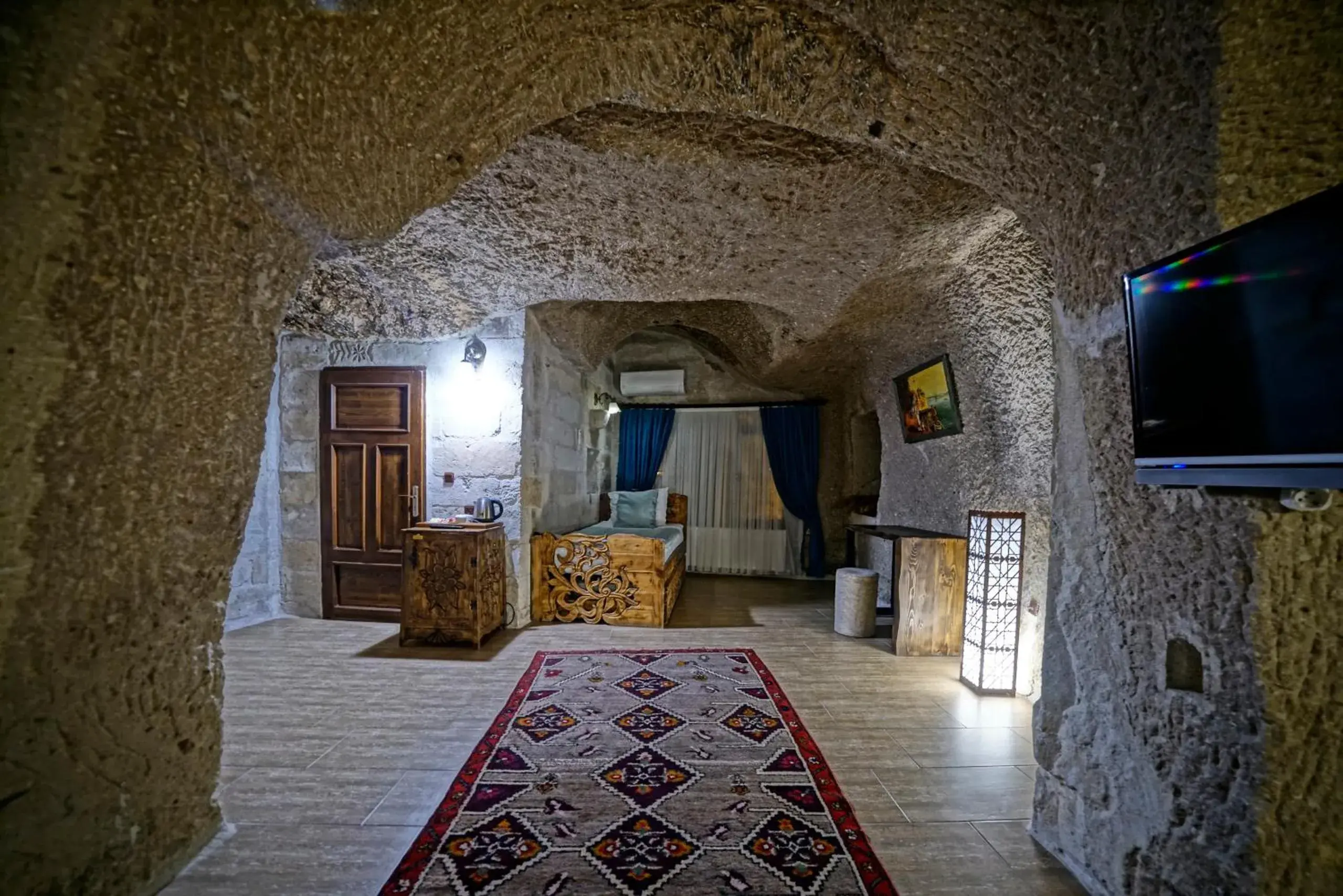 Bed, TV/Entertainment Center in Holiday Cave Hotel