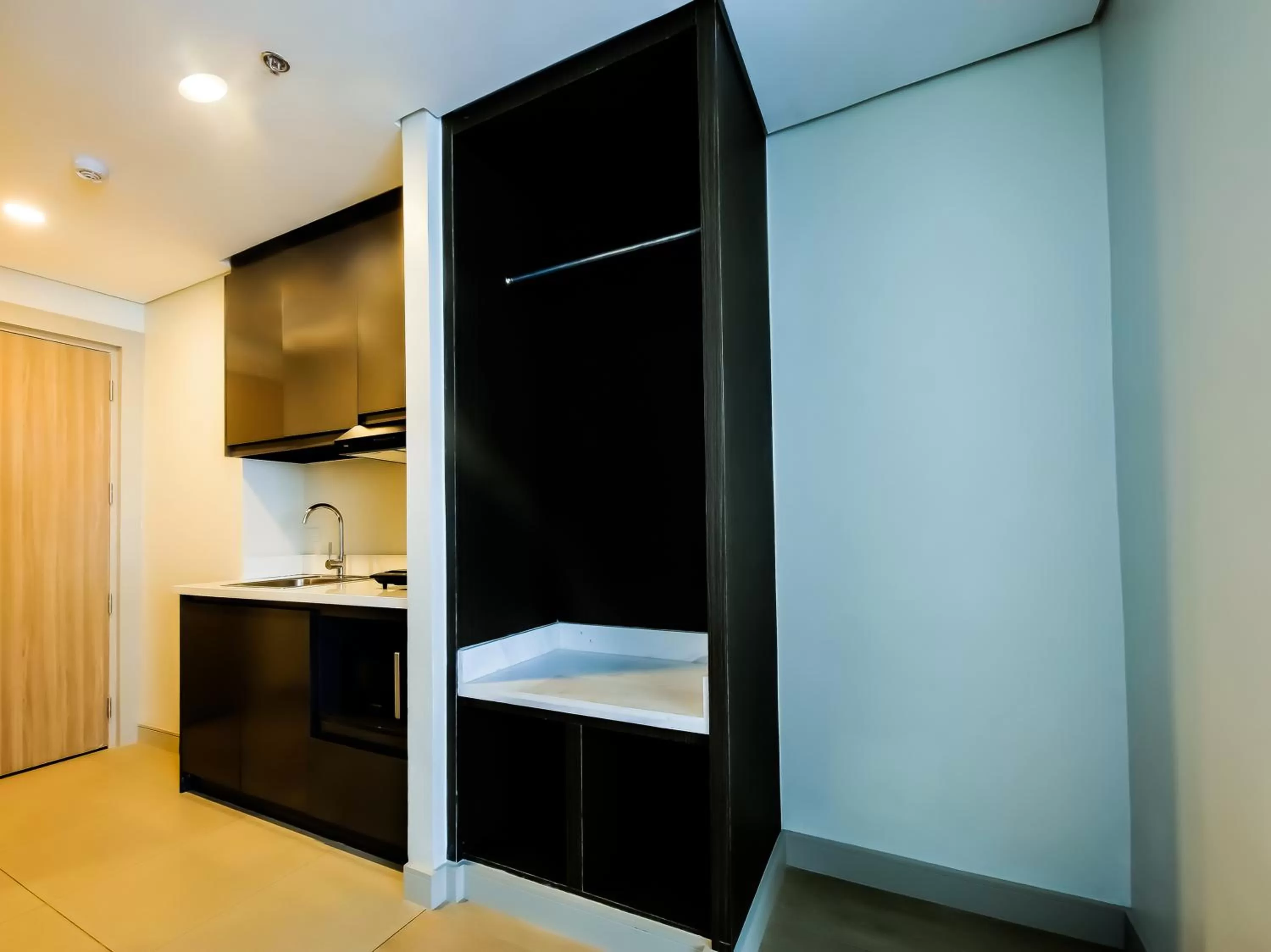 Communal kitchen, TV/Entertainment Center in Capital O 804 The Residences at Bonifacio Civic Center