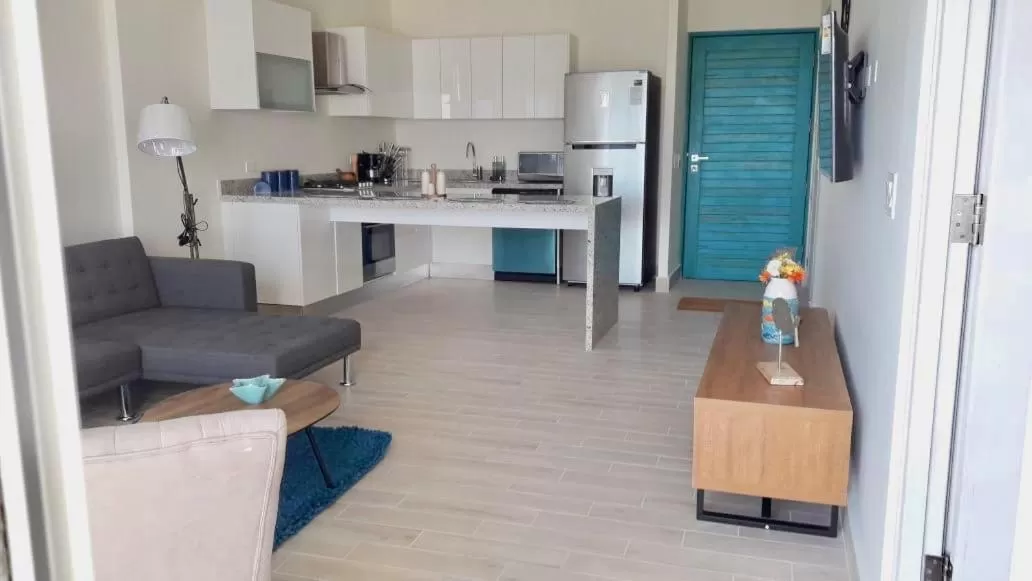 Living room, Kitchen/Kitchenette in Playa Caracol Residences