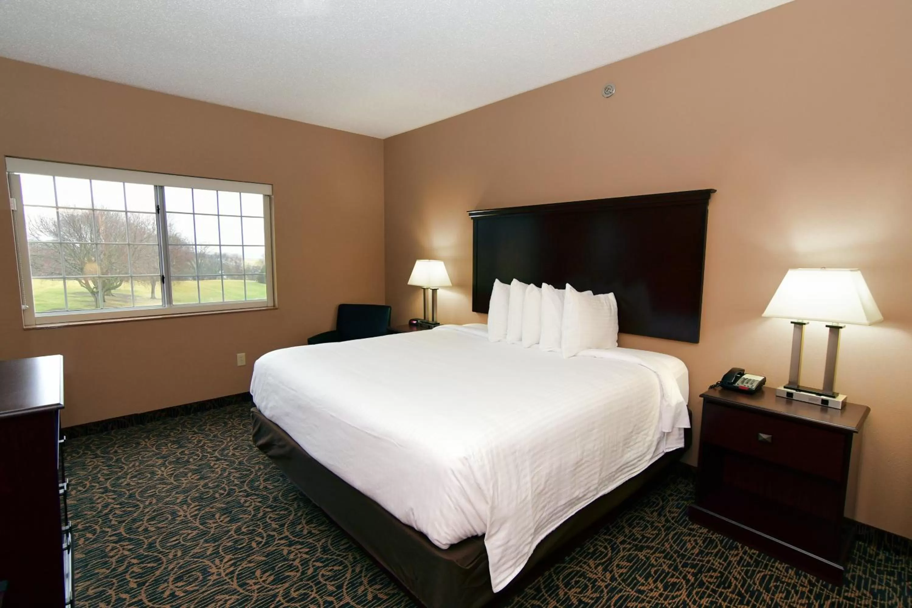 Bed in Cobblestone Inn & Suites - Denison | Majestic Hills