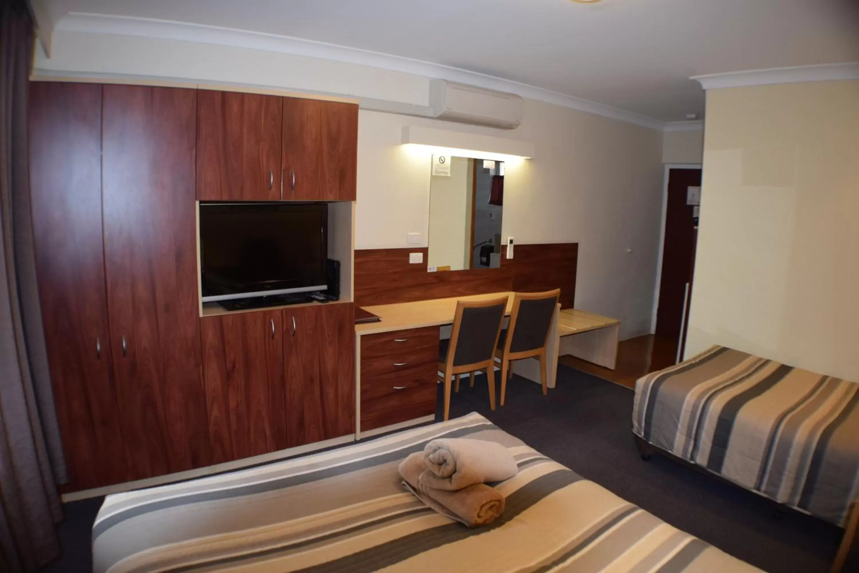 Bed, TV/Entertainment Center in Acacia Motor Inn