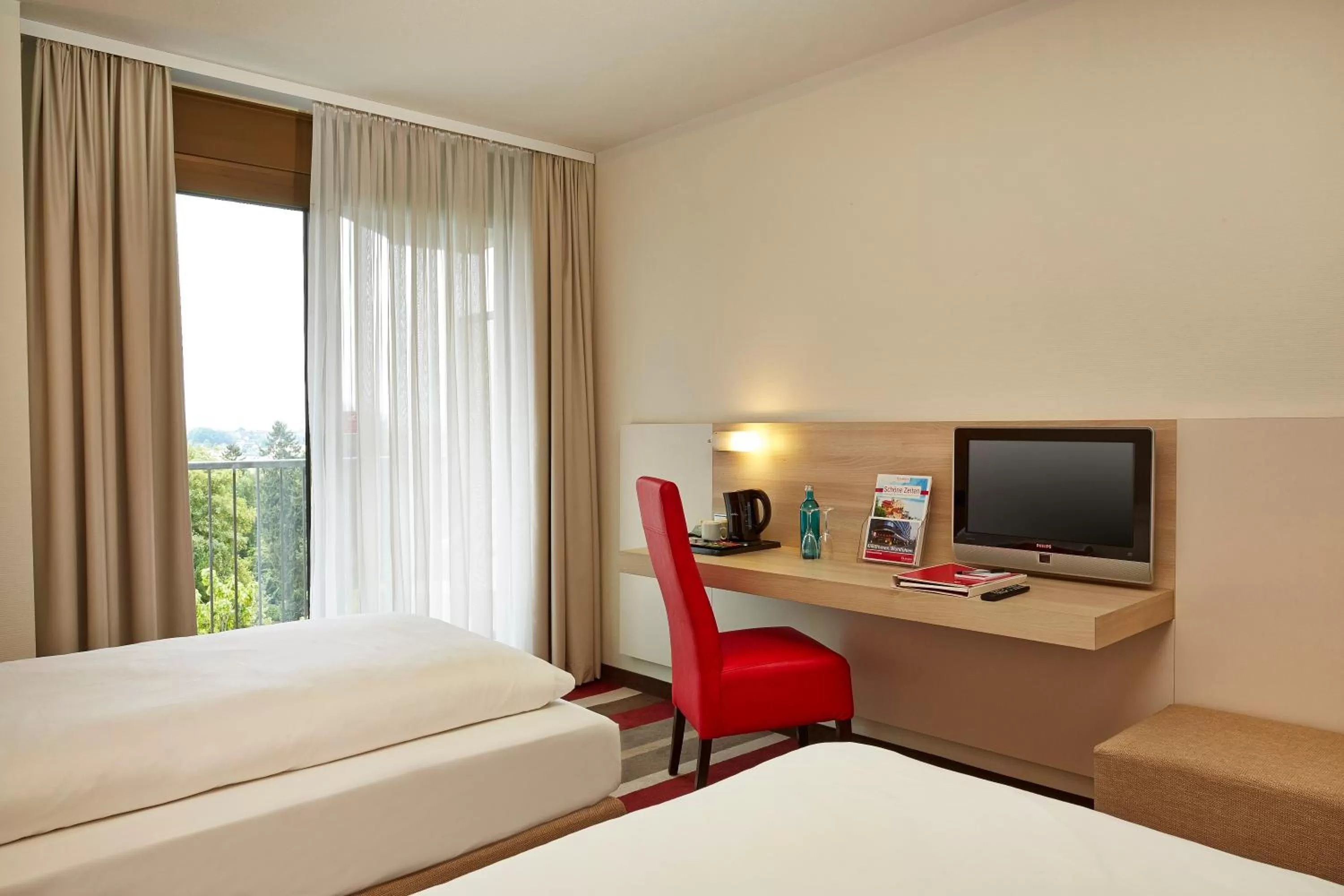 Seating area, Bed in H+ Hotel Bad Soden