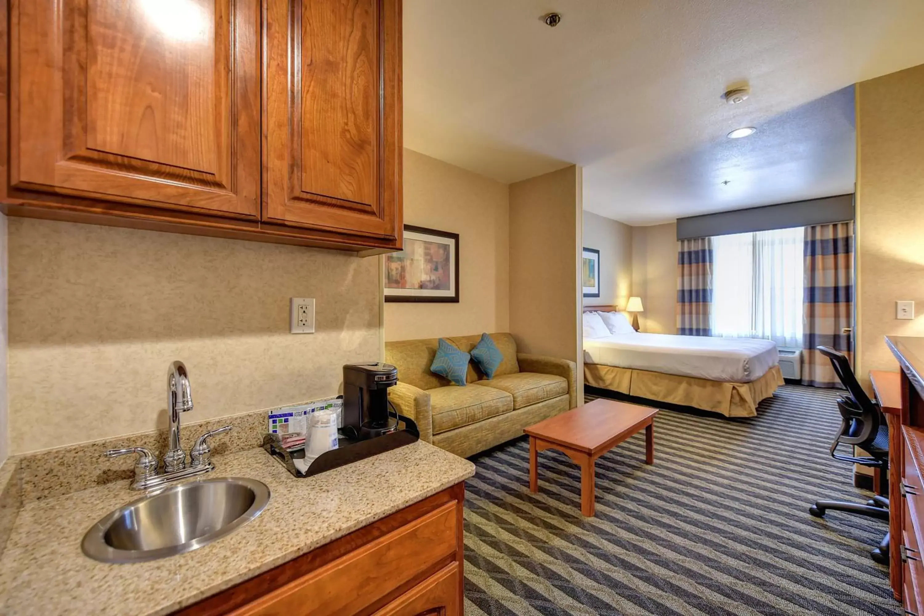 Bedroom, Kitchen/Kitchenette in Holiday Inn Express Hotel & Suites Manteca, an IHG Hotel