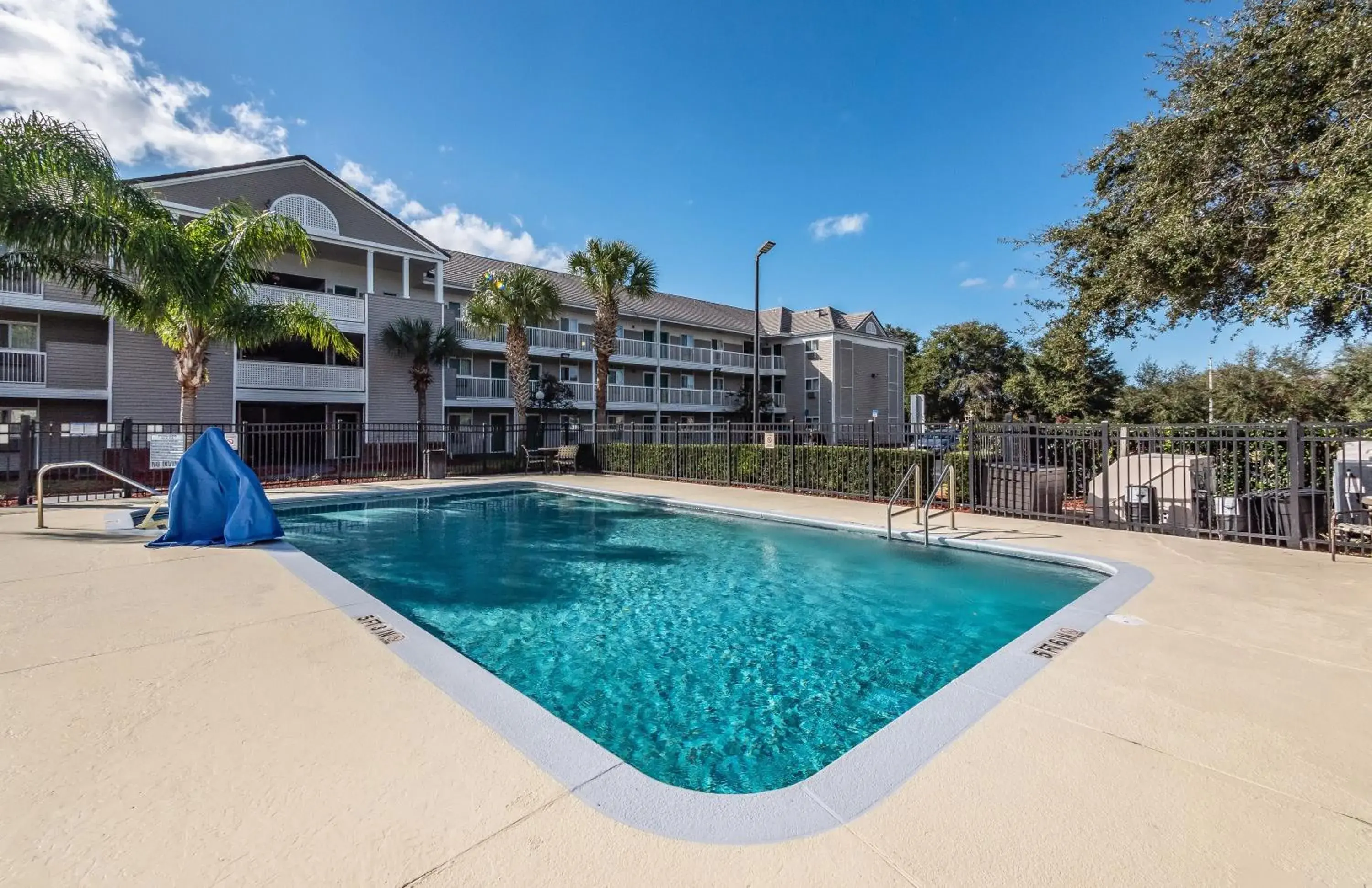 Swimming pool, Property Building in HomeTowne Studios by Red Roof Orlando South
