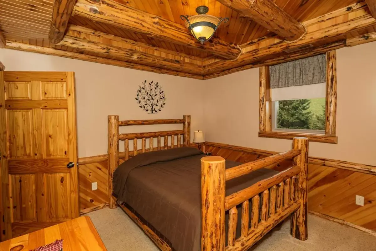 Bed in Sojourner's Lodge & Log Cabin Suites