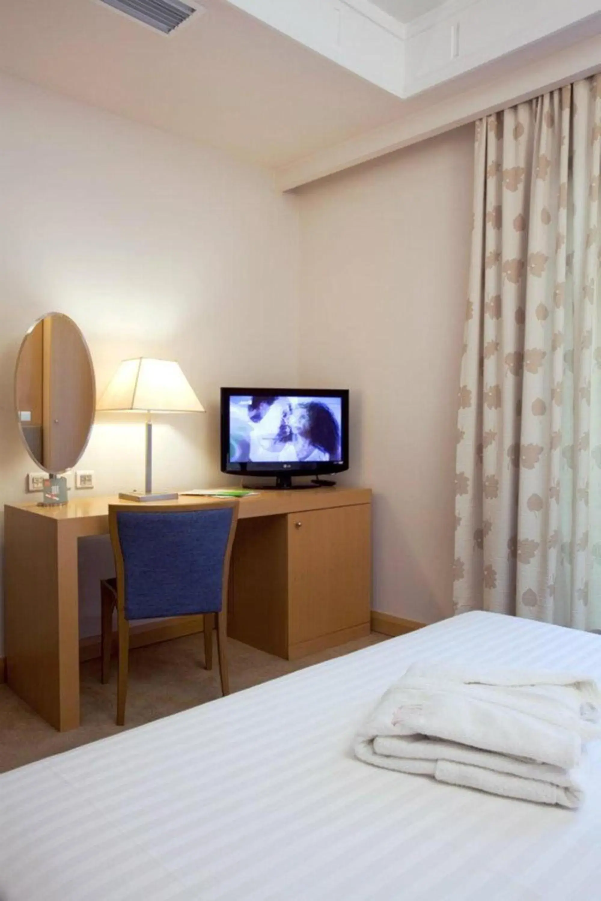 Bed, TV/Entertainment Center in Central Hotel