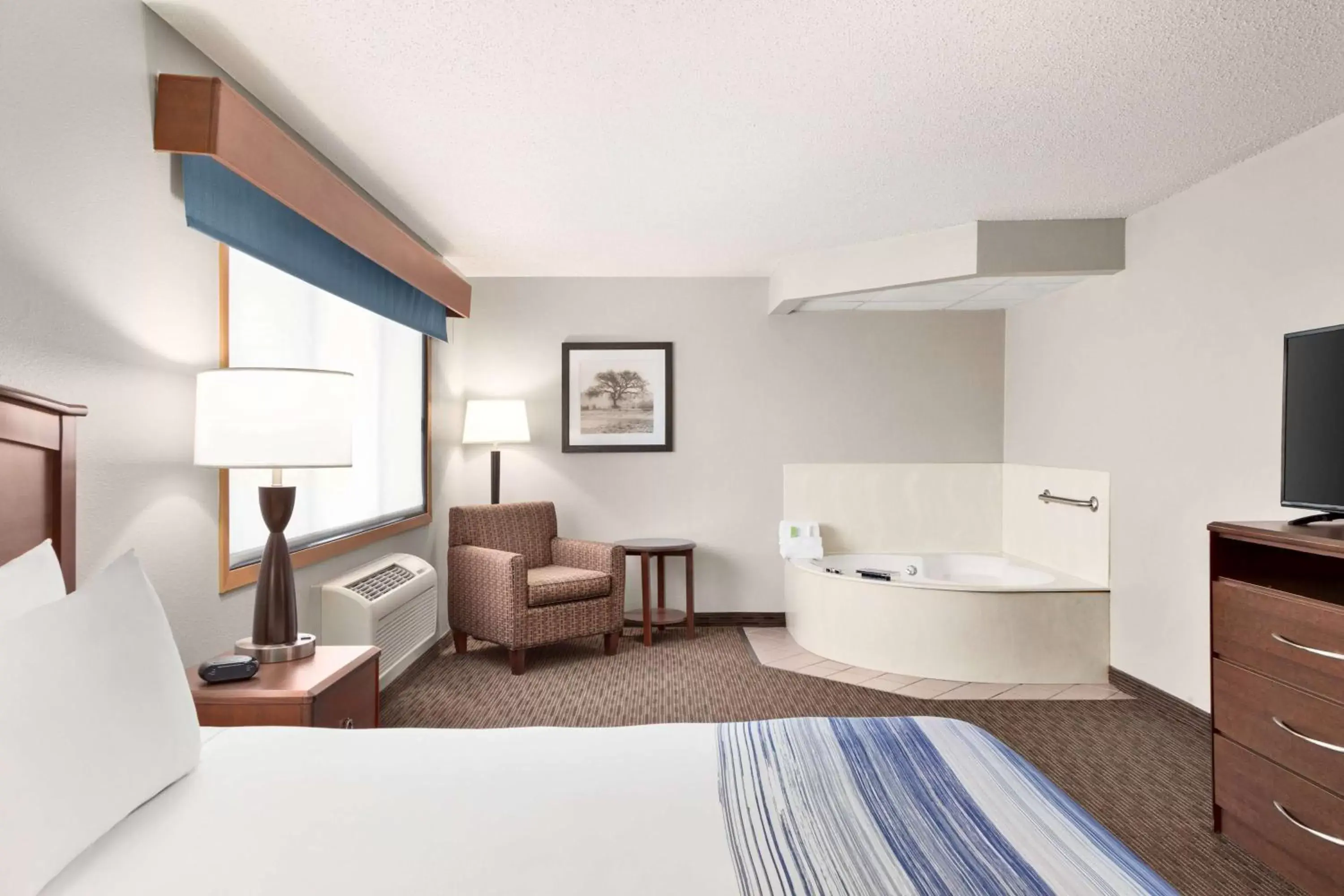 Bed, Seating Area in AmericInn by Wyndham Sauk Centre