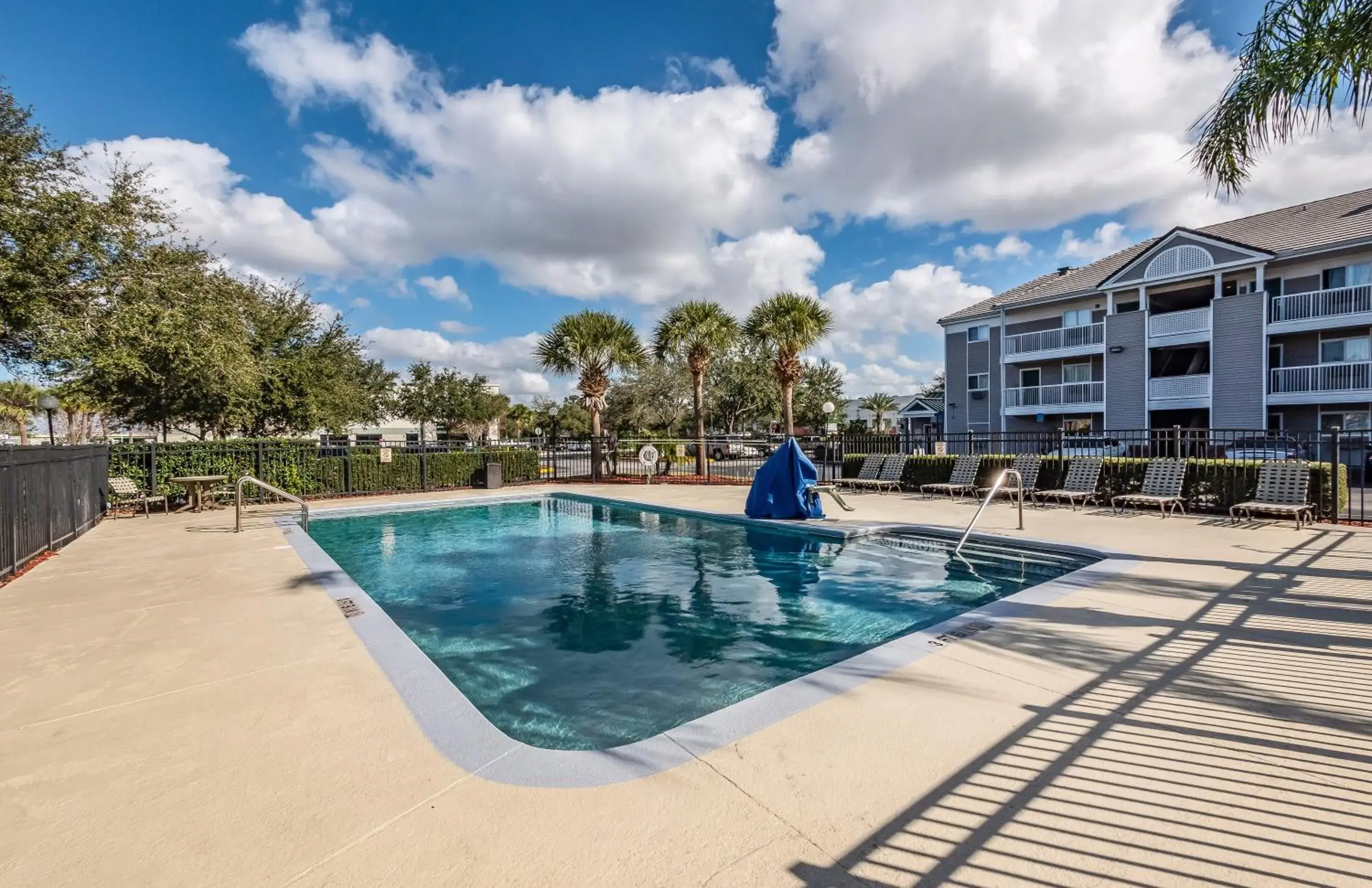 Swimming pool, Property Building in HomeTowne Studios by Red Roof Orlando South