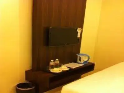 Bed, TV/Entertainment Center in The Regency Garden Hotel