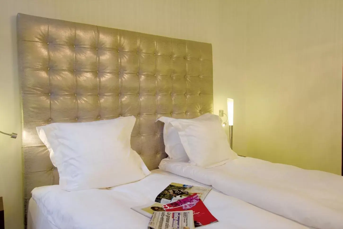 Bed in GOLDEN TULIP CANNES HOTEL de PARIS