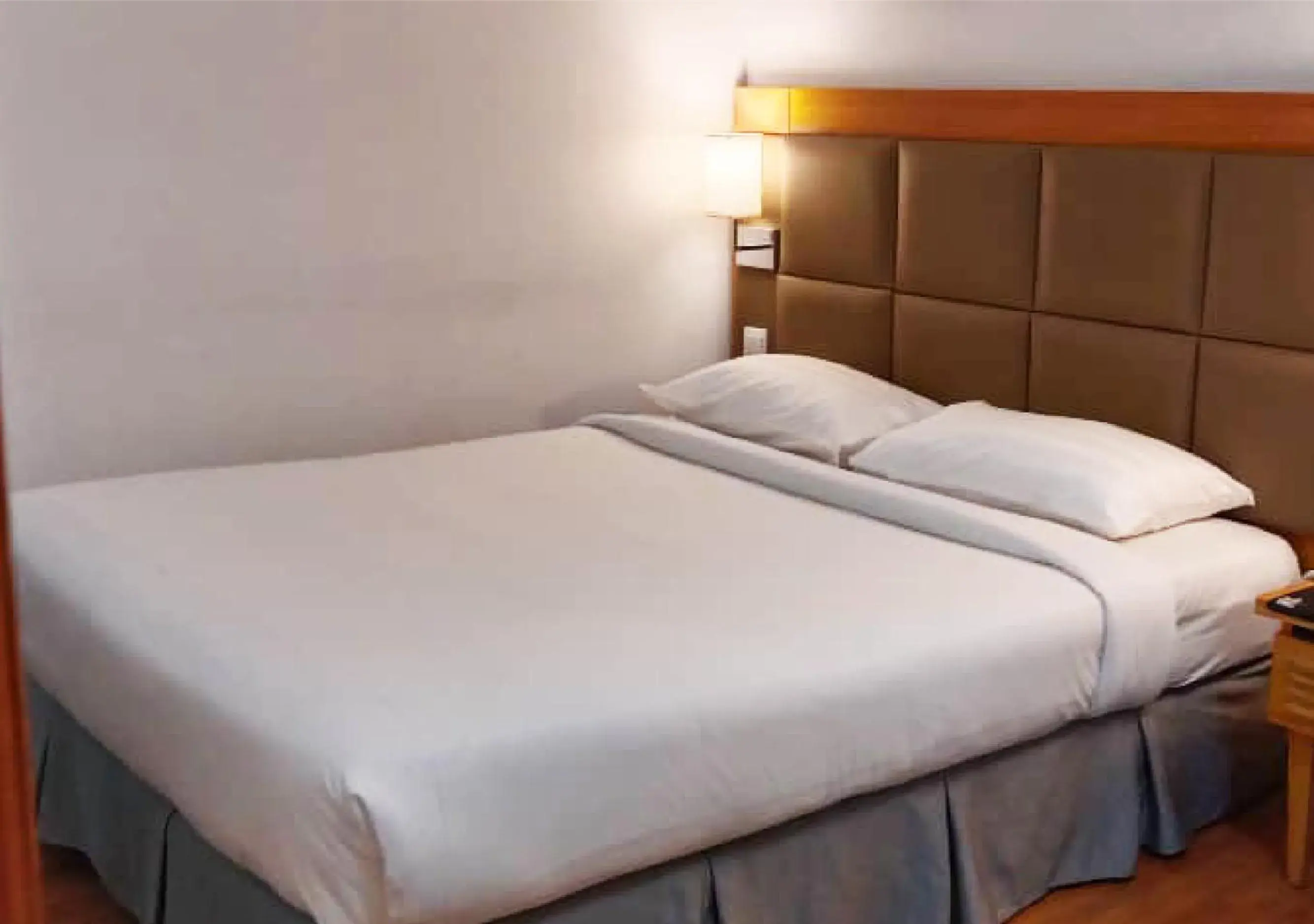 Bed in Crown Garden Hotel