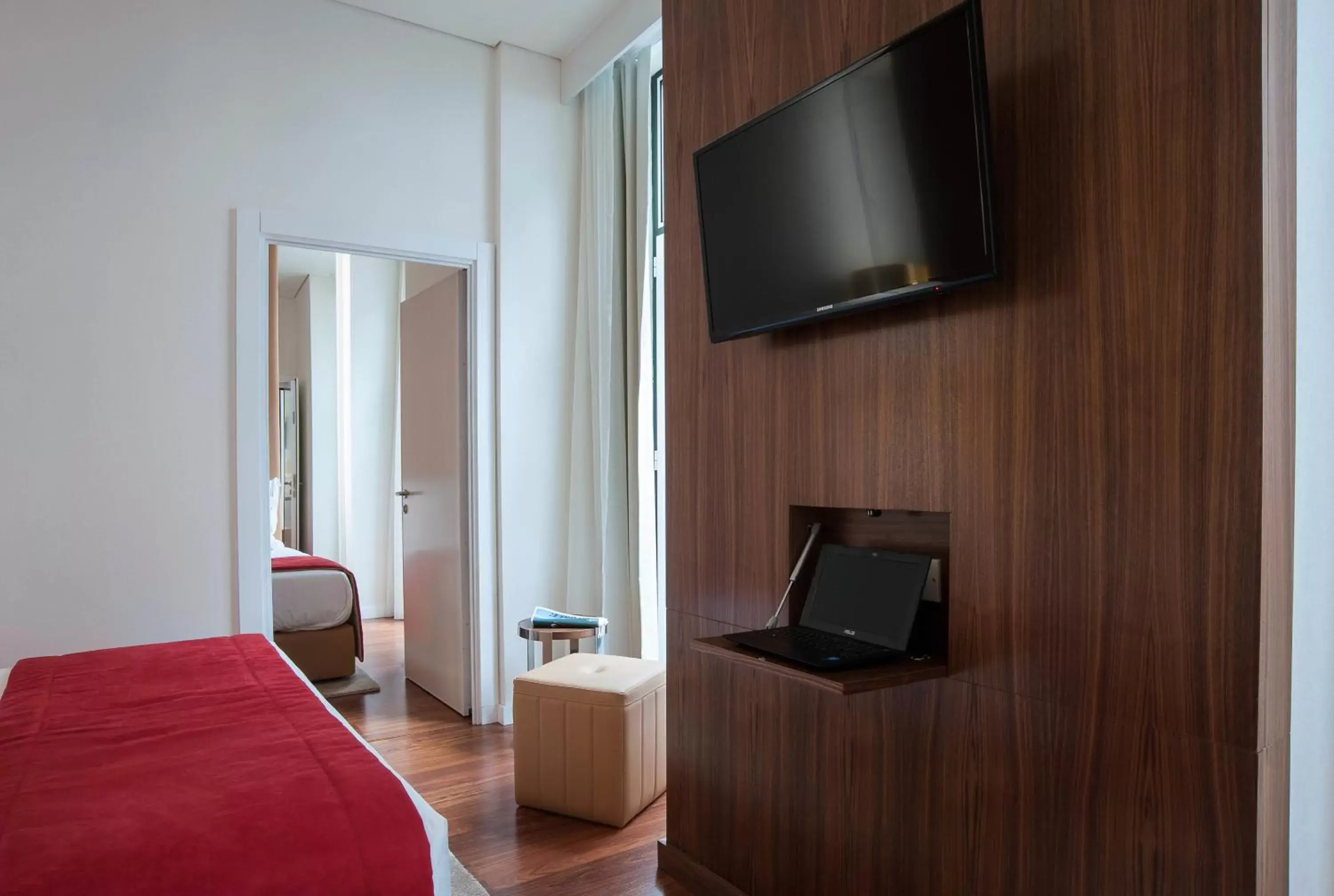 Bed, TV/Entertainment Center in The 7 Hotel, Suites, Studios & Apartments