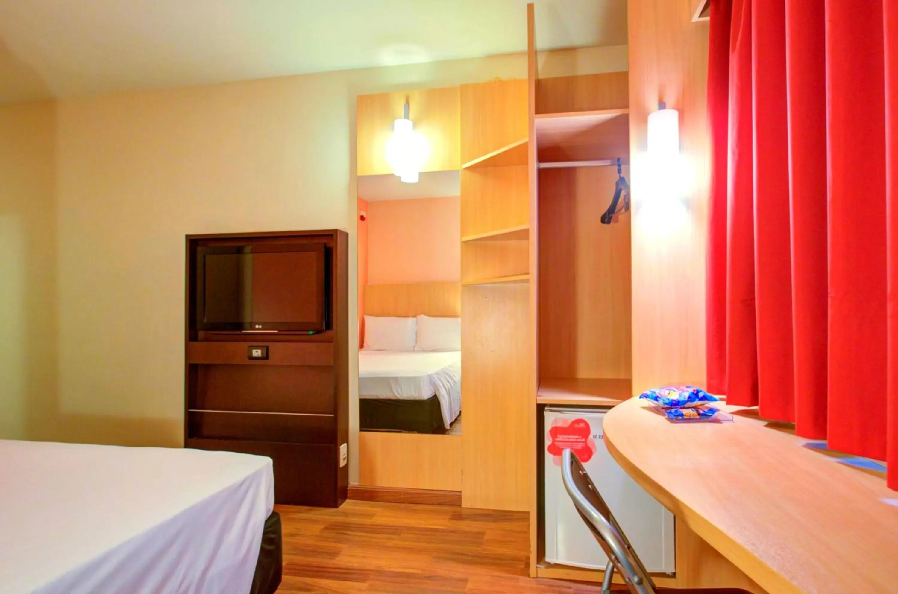 Bed, TV/Entertainment Center in ibis Vitoria Praia de Camburi