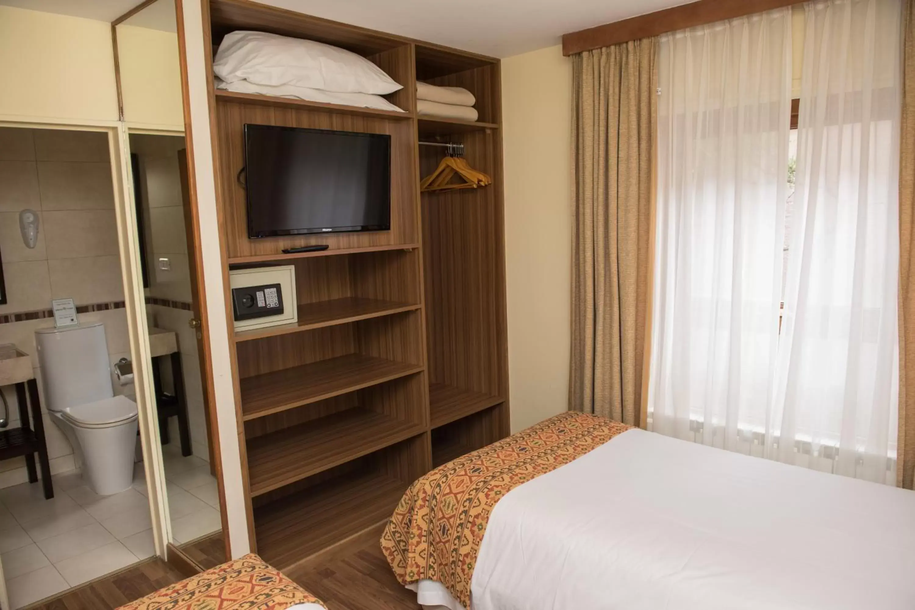 Bed, TV/Entertainment Center in Del Bosque Apart Hotel