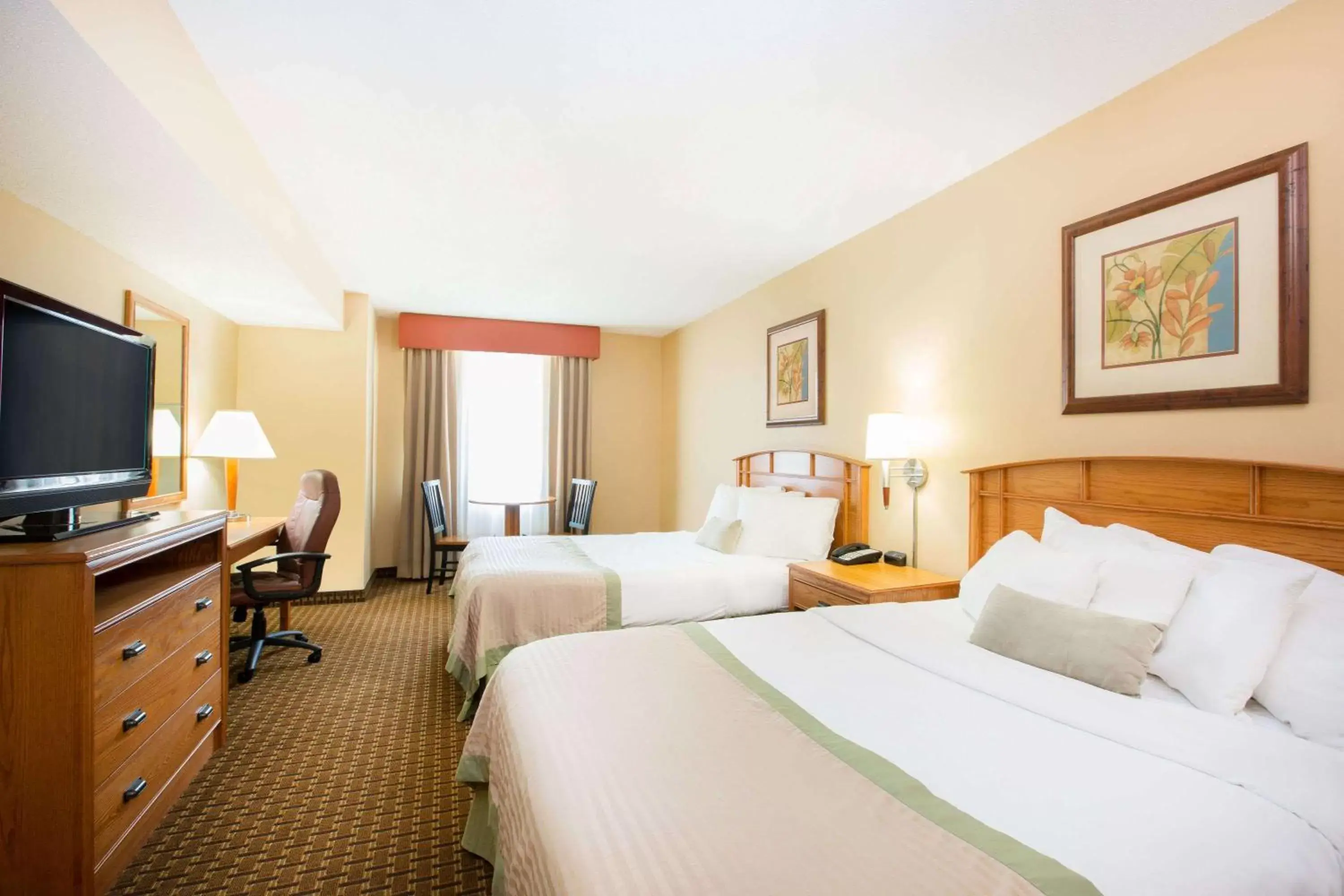 Bed in Ramada by Wyndham Des Moines Tropics Resort & Conference Ctr
