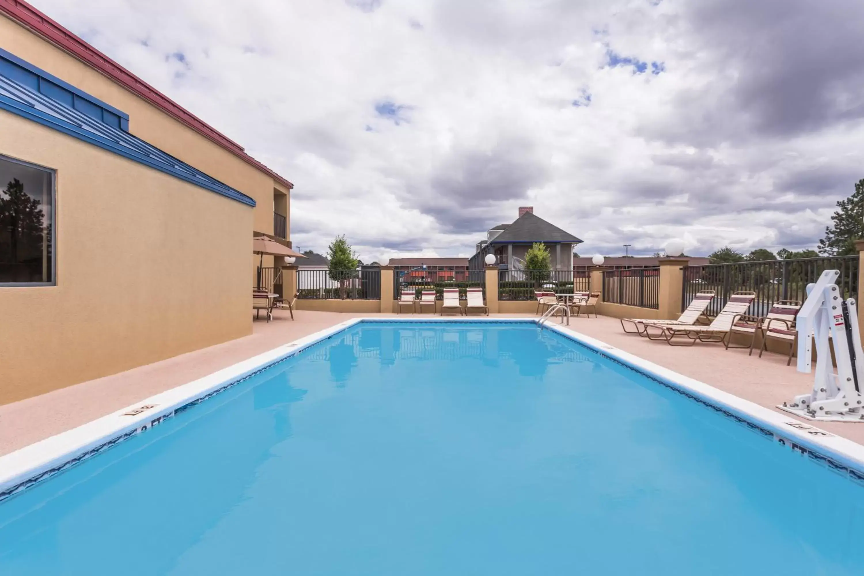 Property building, Swimming Pool in Days Inn & Suites by Wyndham Warner Robins Near Robins AFB