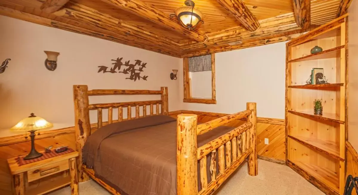 Bed in Sojourner's Lodge & Log Cabin Suites