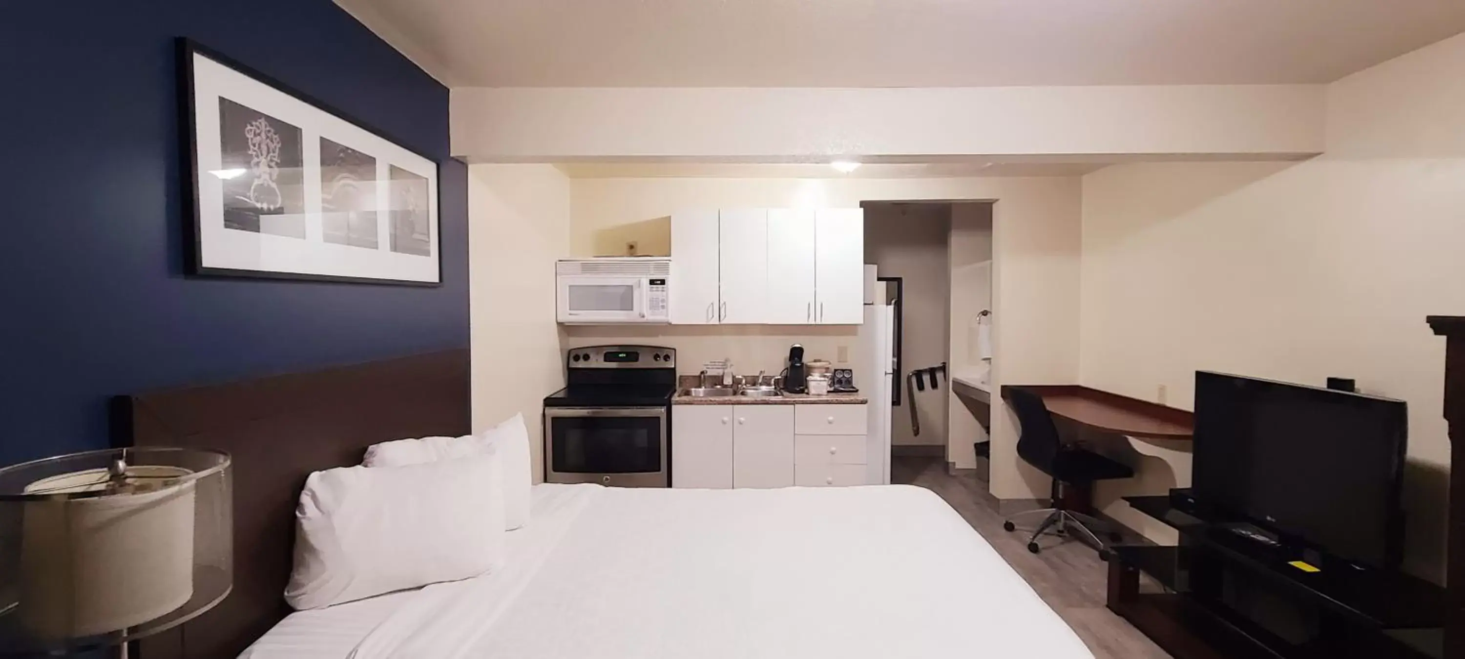 Bedroom, Kitchen/Kitchenette in Empire Inn & Suites