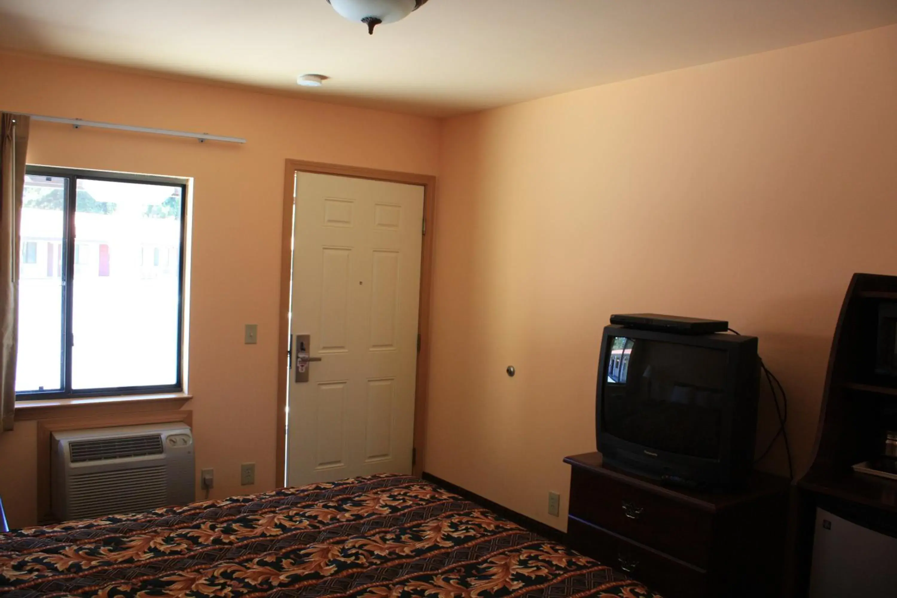 Bed, TV/Entertainment Center in Gold Trail Motor Lodge