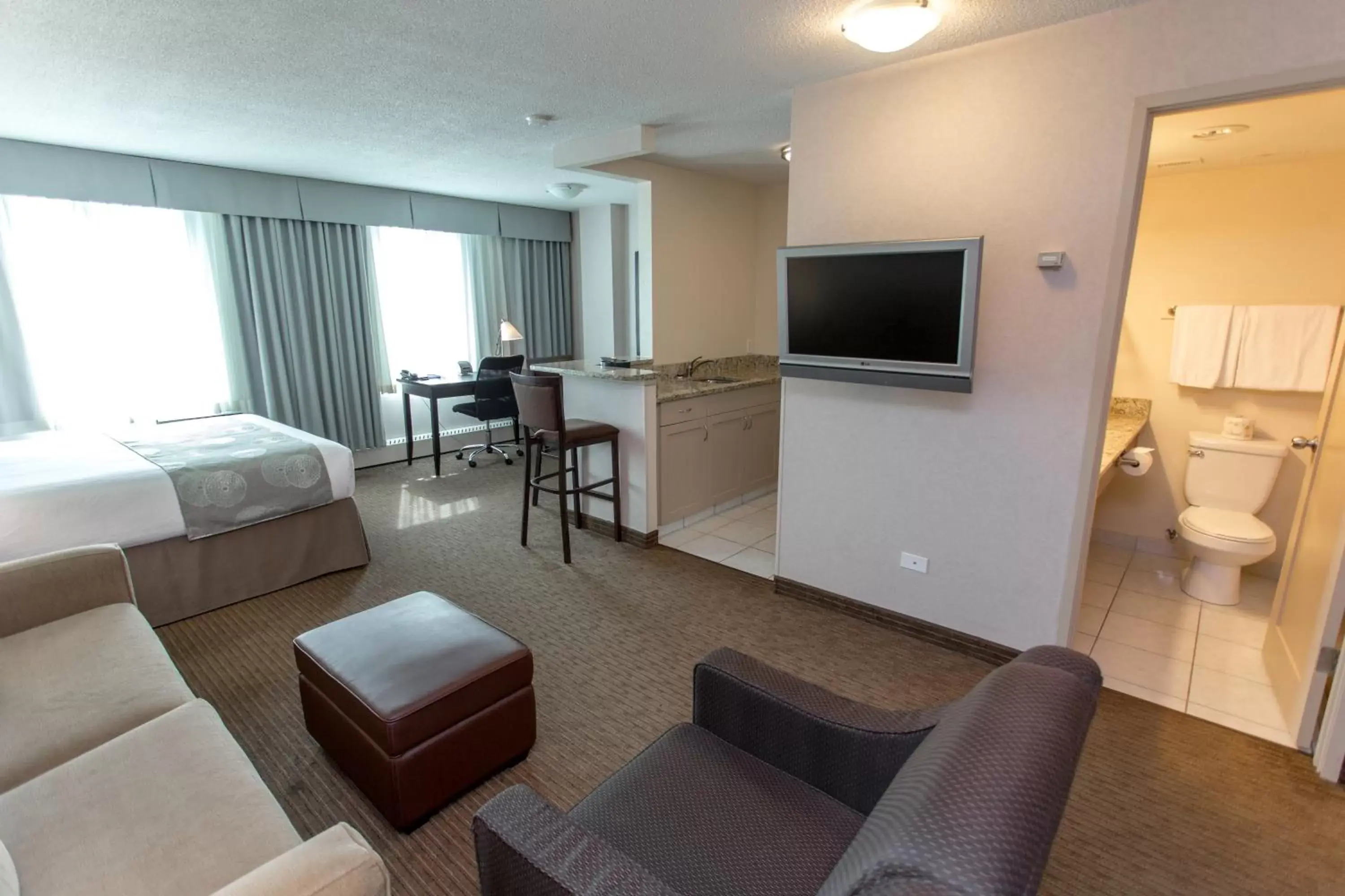 Bed, Seating Area in Campus Tower Suite Hotel