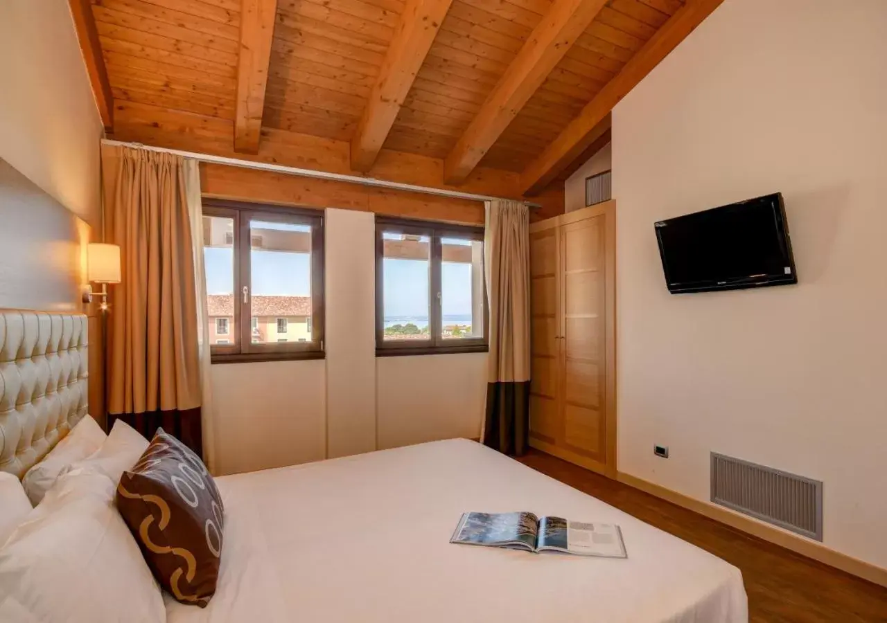 Bed, TV/Entertainment Center in TH Lazise - Hotel Parchi Del Garda