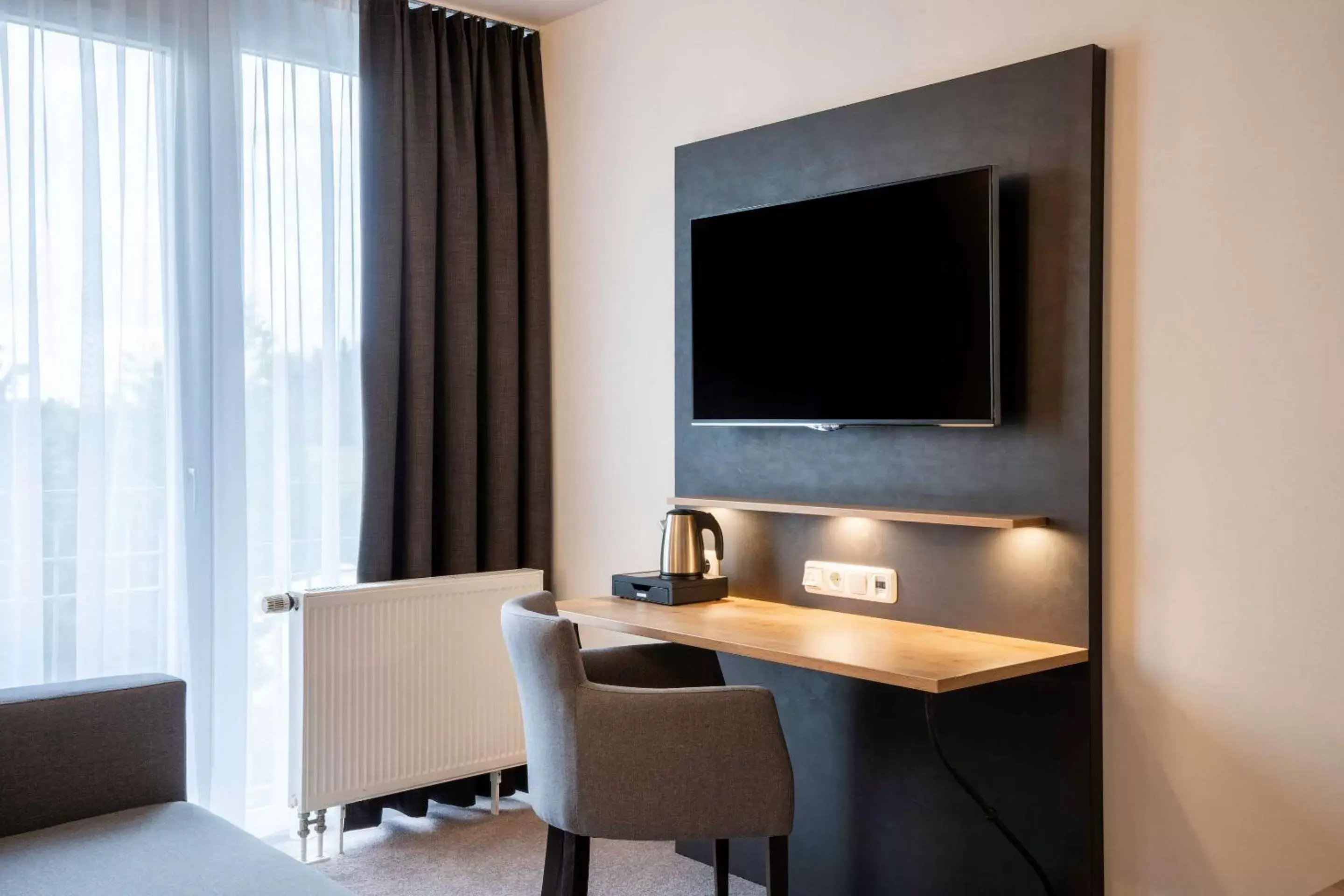 Photo of the whole room, TV/Entertainment Center in Quality Hotel & Suites Muenchen Messe