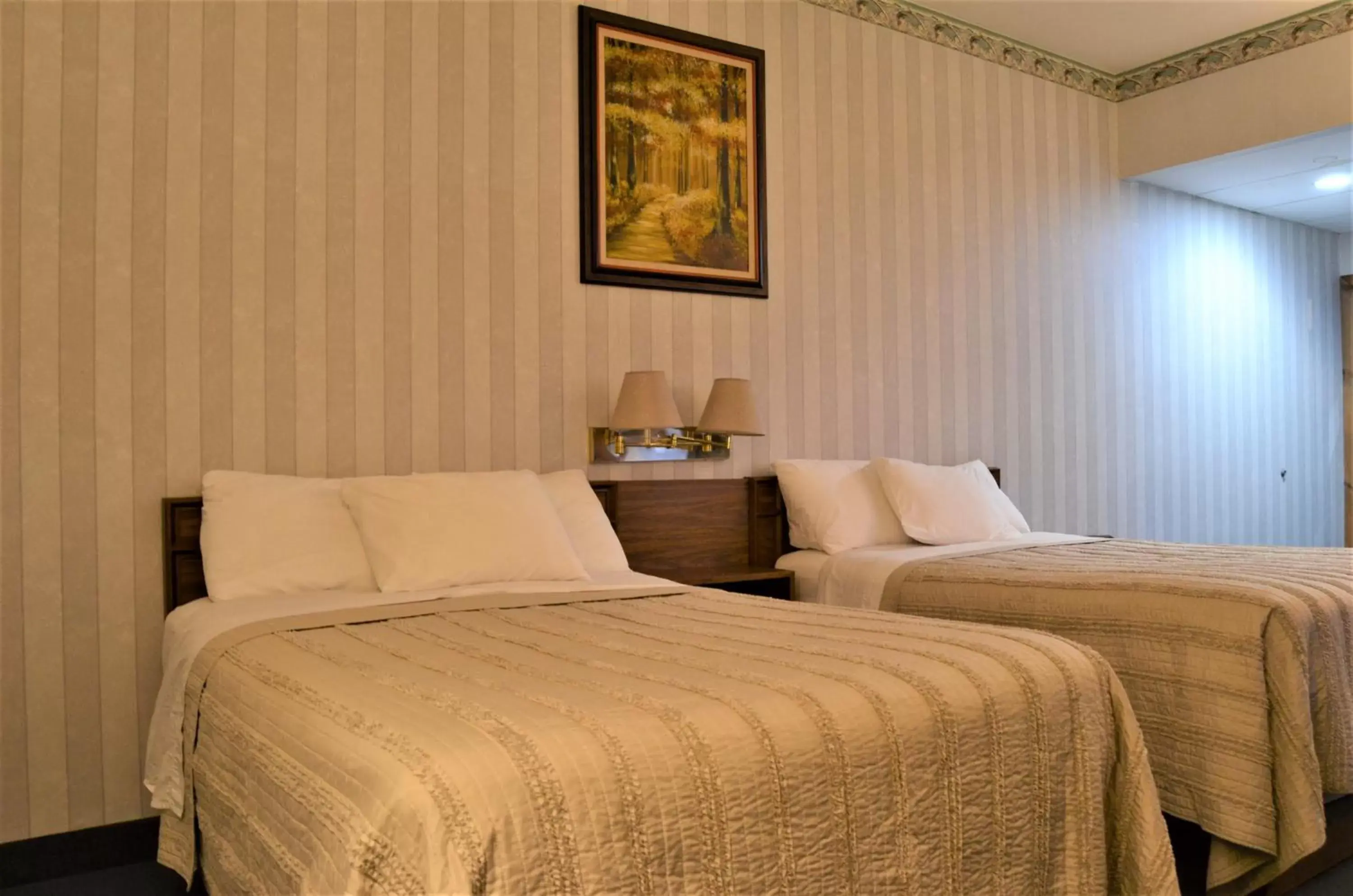 Bed in Lake Ontario Motel & Inn