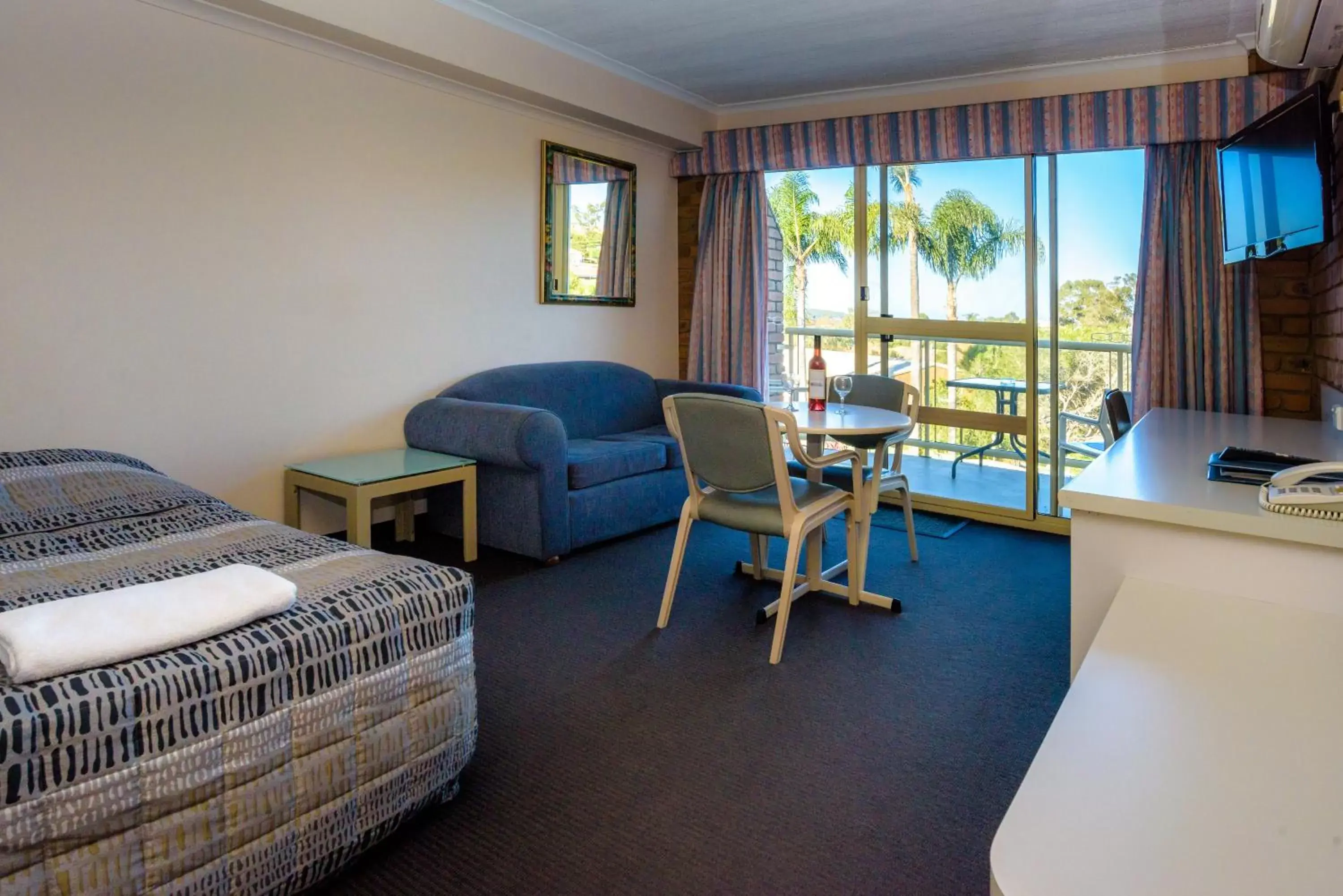 Bed, Seating Area in Sapphire Waters Motor Inn