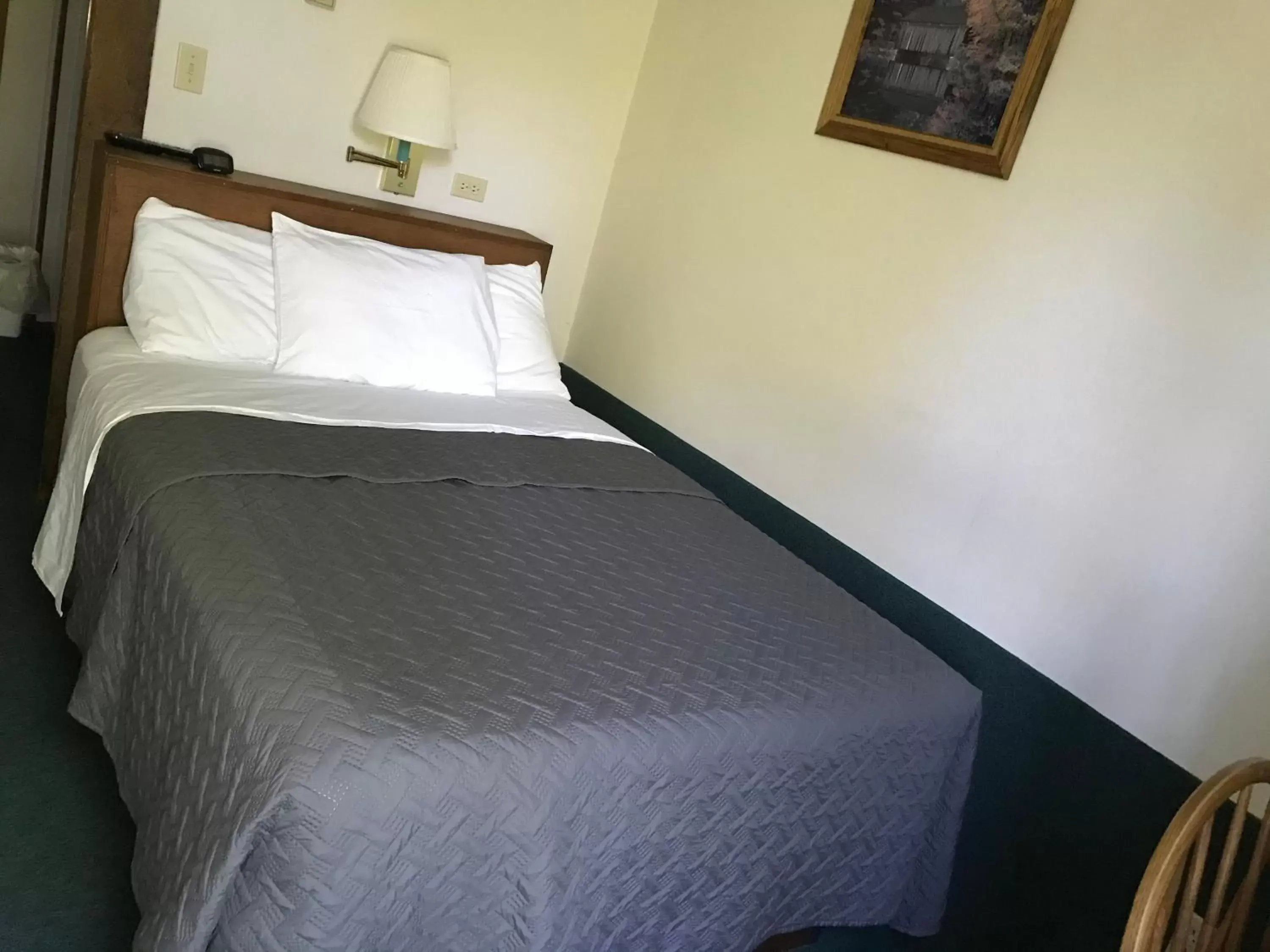 Bed in Lake Ontario Motel & Inn
