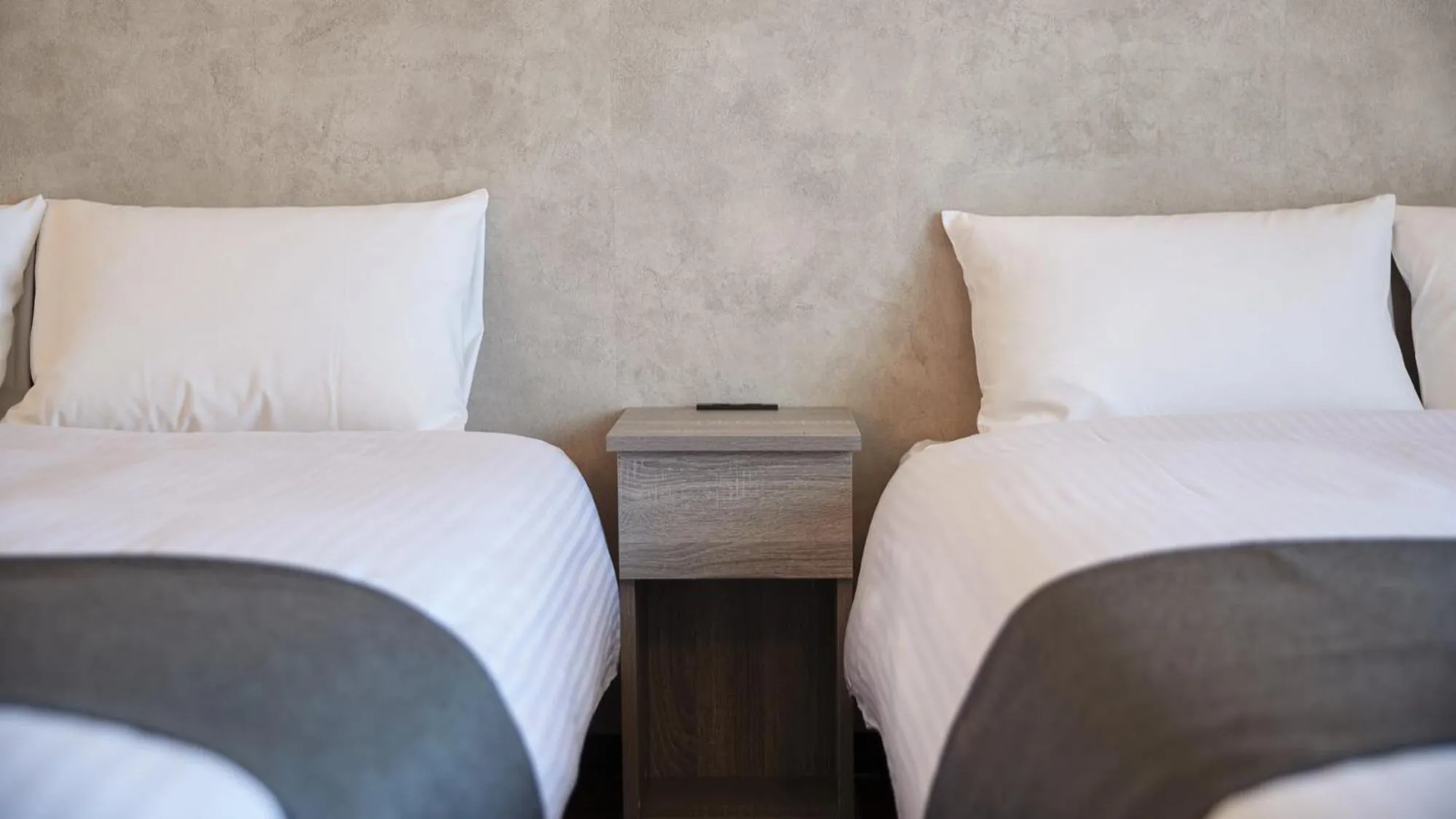 Bed in New Normal Hotel in NAMINOUE ニューノーマルホテルイン波の上