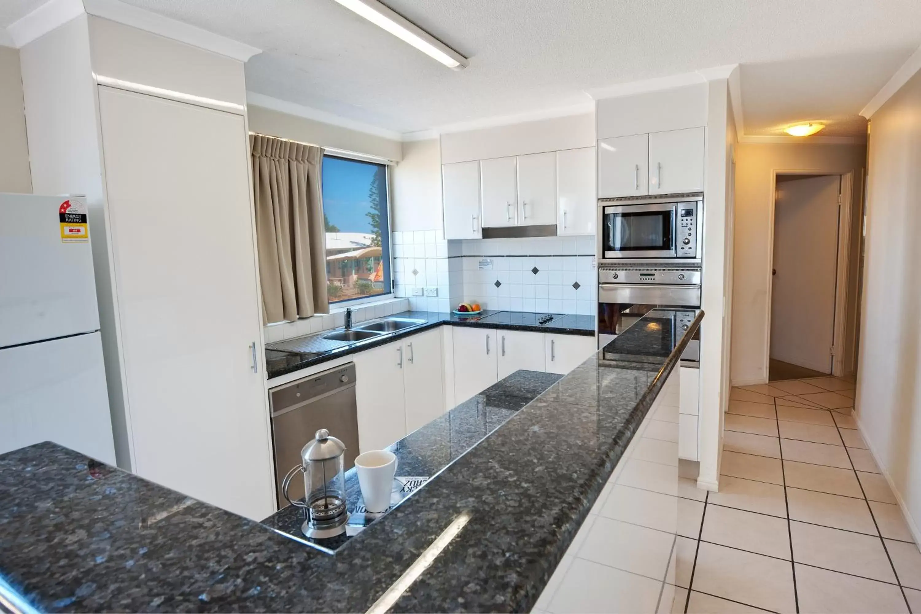 Living room, Kitchen/Kitchenette in Bargara Blue Resort