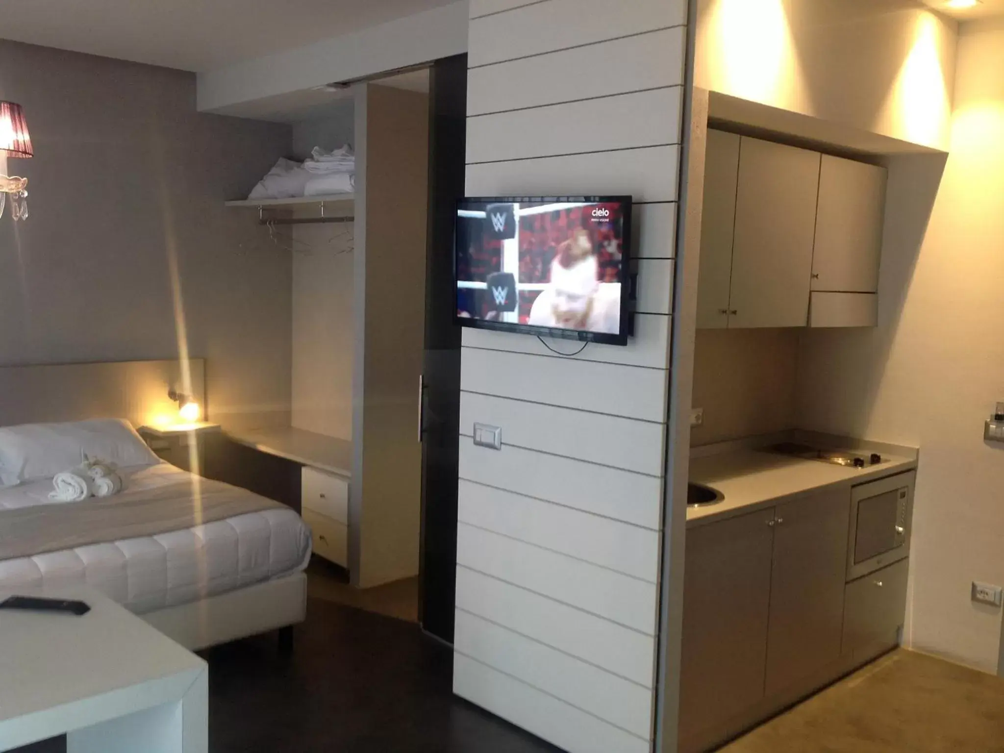 Bed, TV/Entertainment Center in Bell Suite Hotel