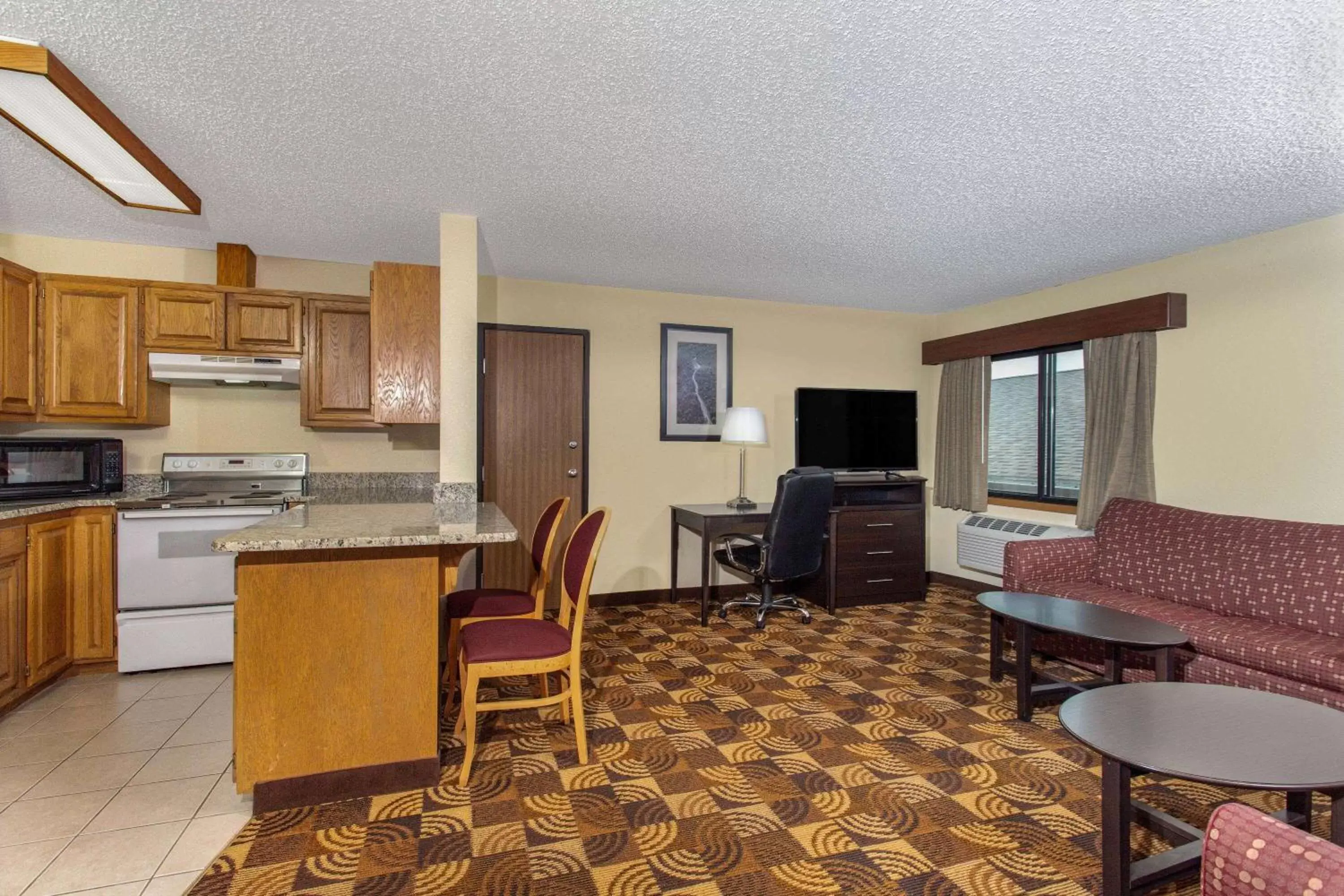 Bed, Kitchen/Kitchenette in AmericInn by Wyndham Elkhorn Near Lake Geneva