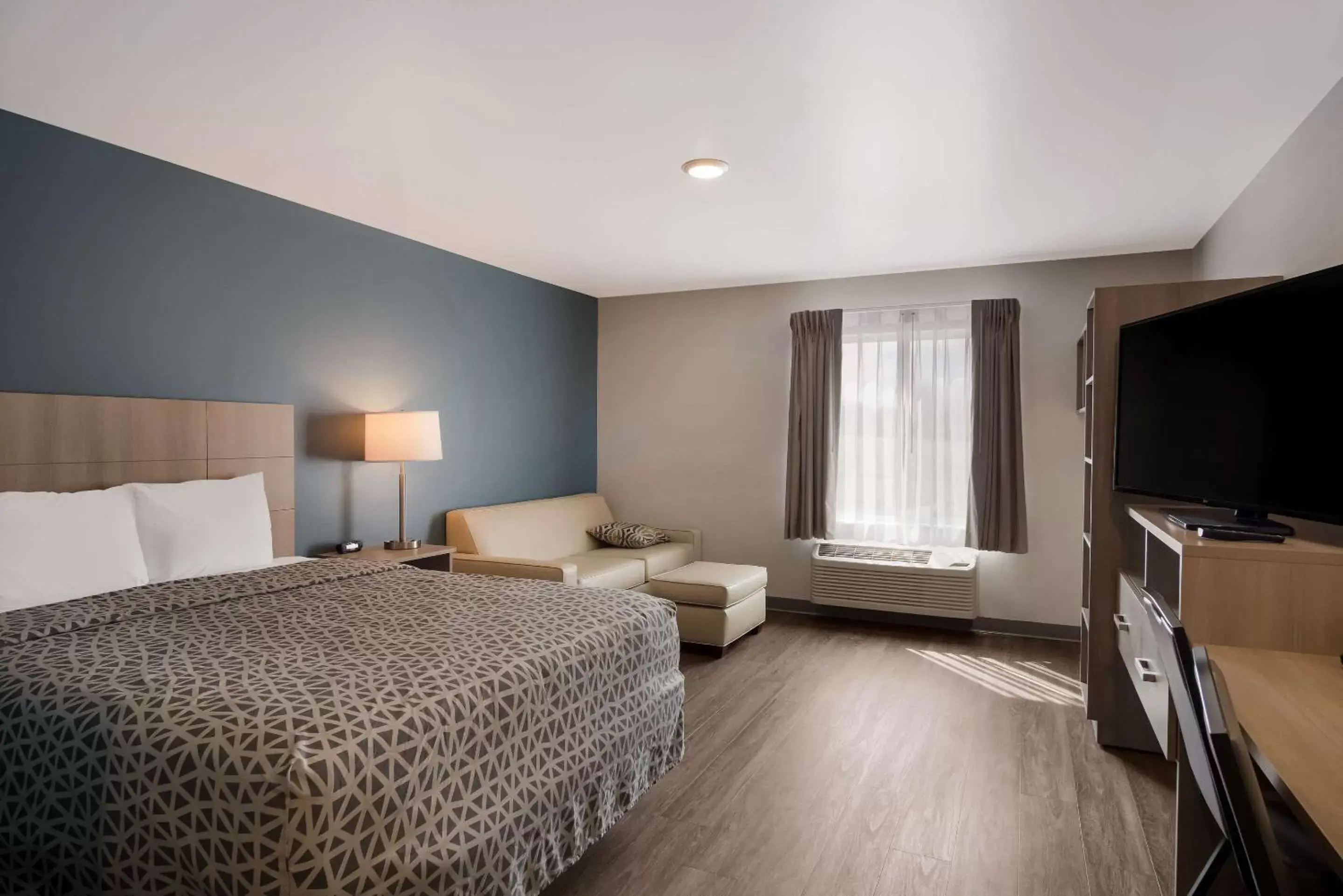 Bedroom, TV/Entertainment Center in WoodSpring Suites Grand Rapids Kentwood