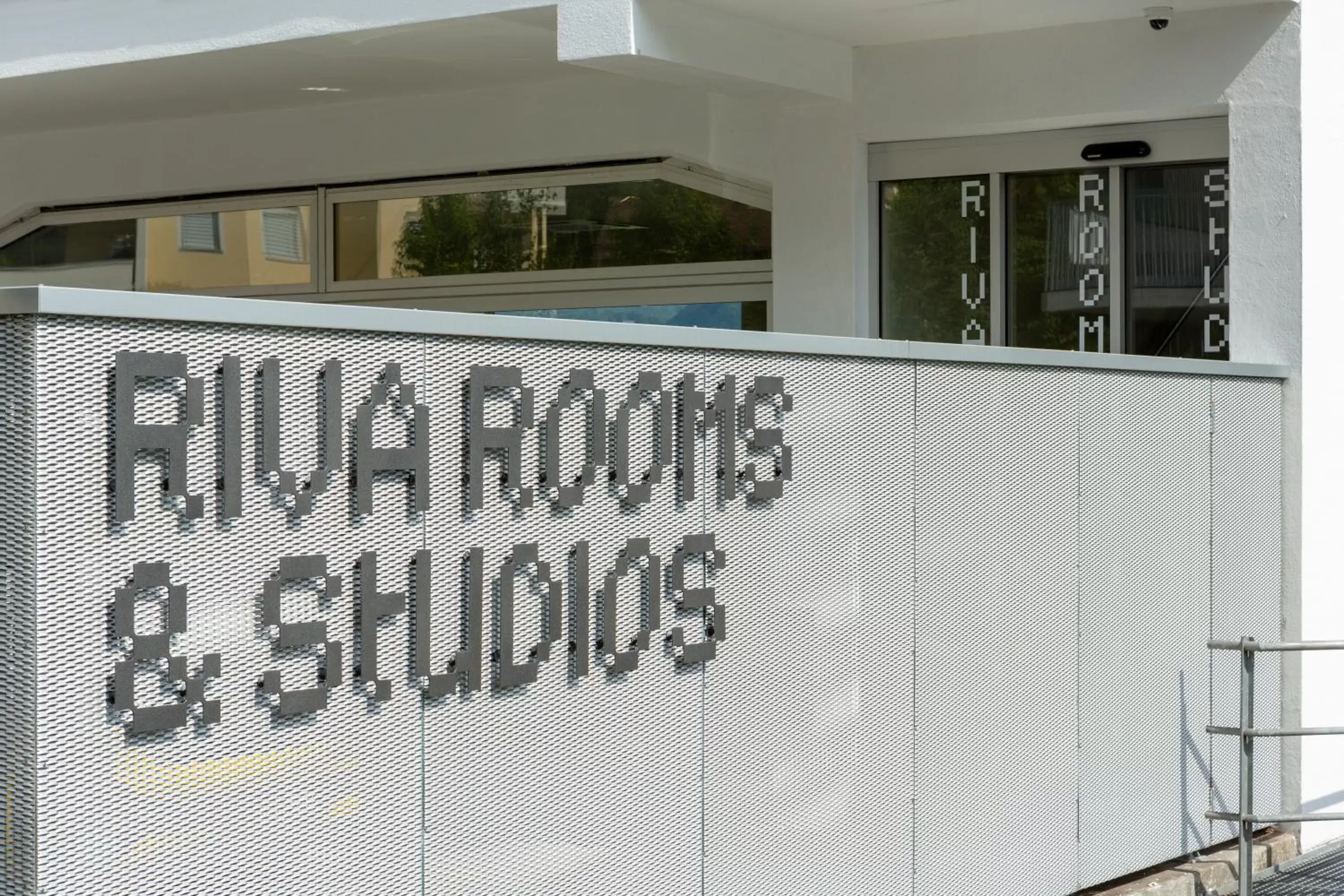 Property logo or sign in Riva Rooms & Studios - Check-In 24hr