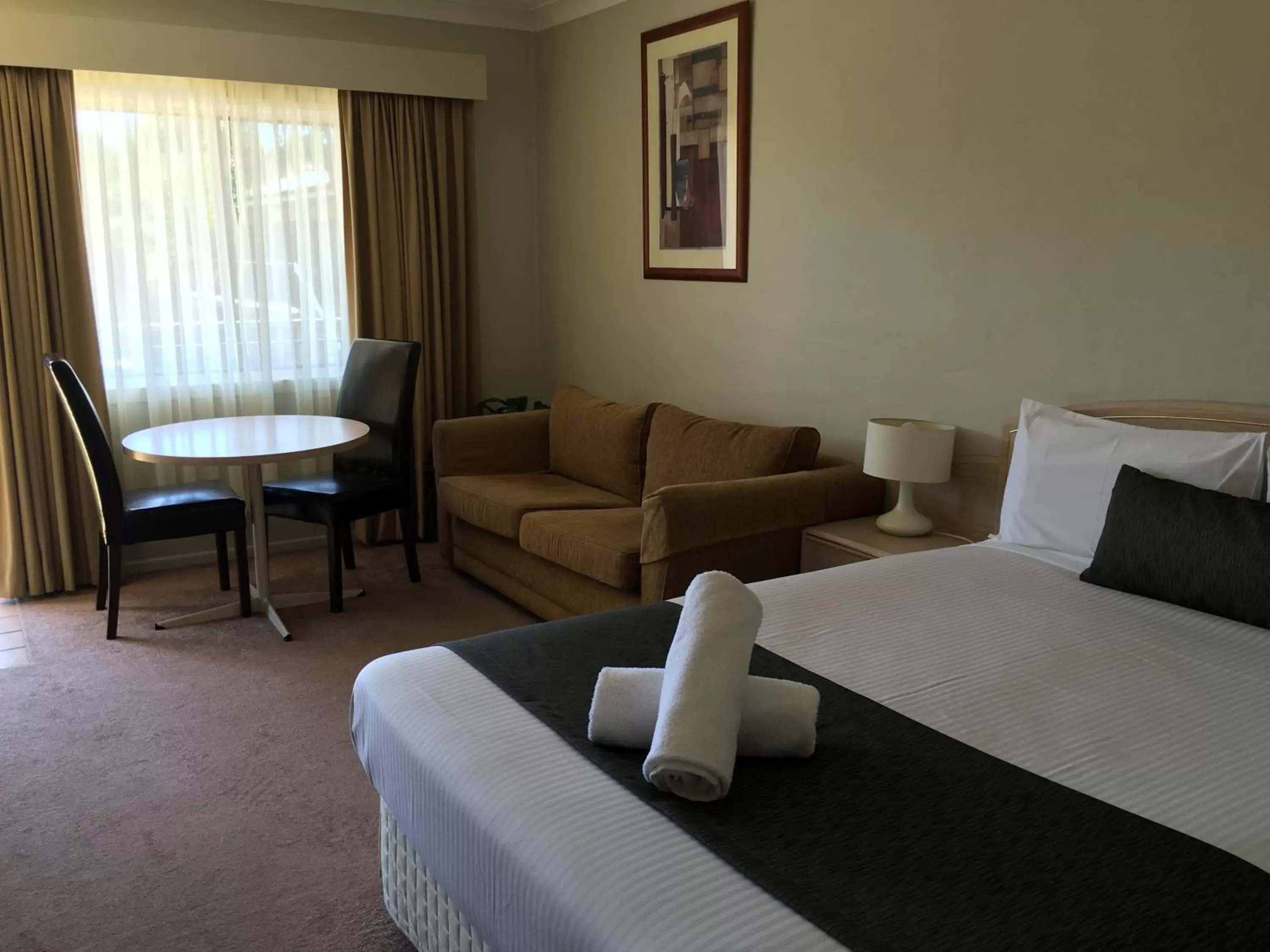 Bed, Seating Area in Araluen Motor Lodge