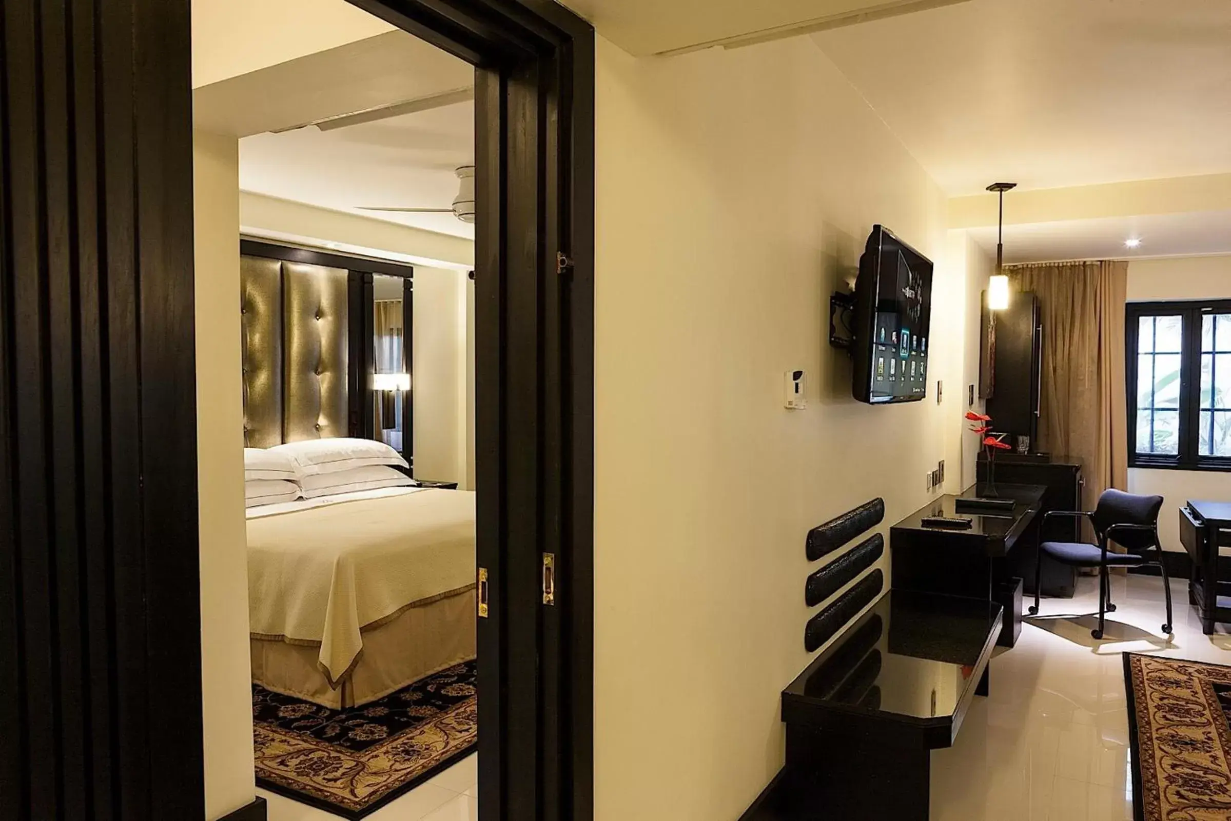 Communal lounge/ TV room, Bed in Terra Nova All Suite Hotel