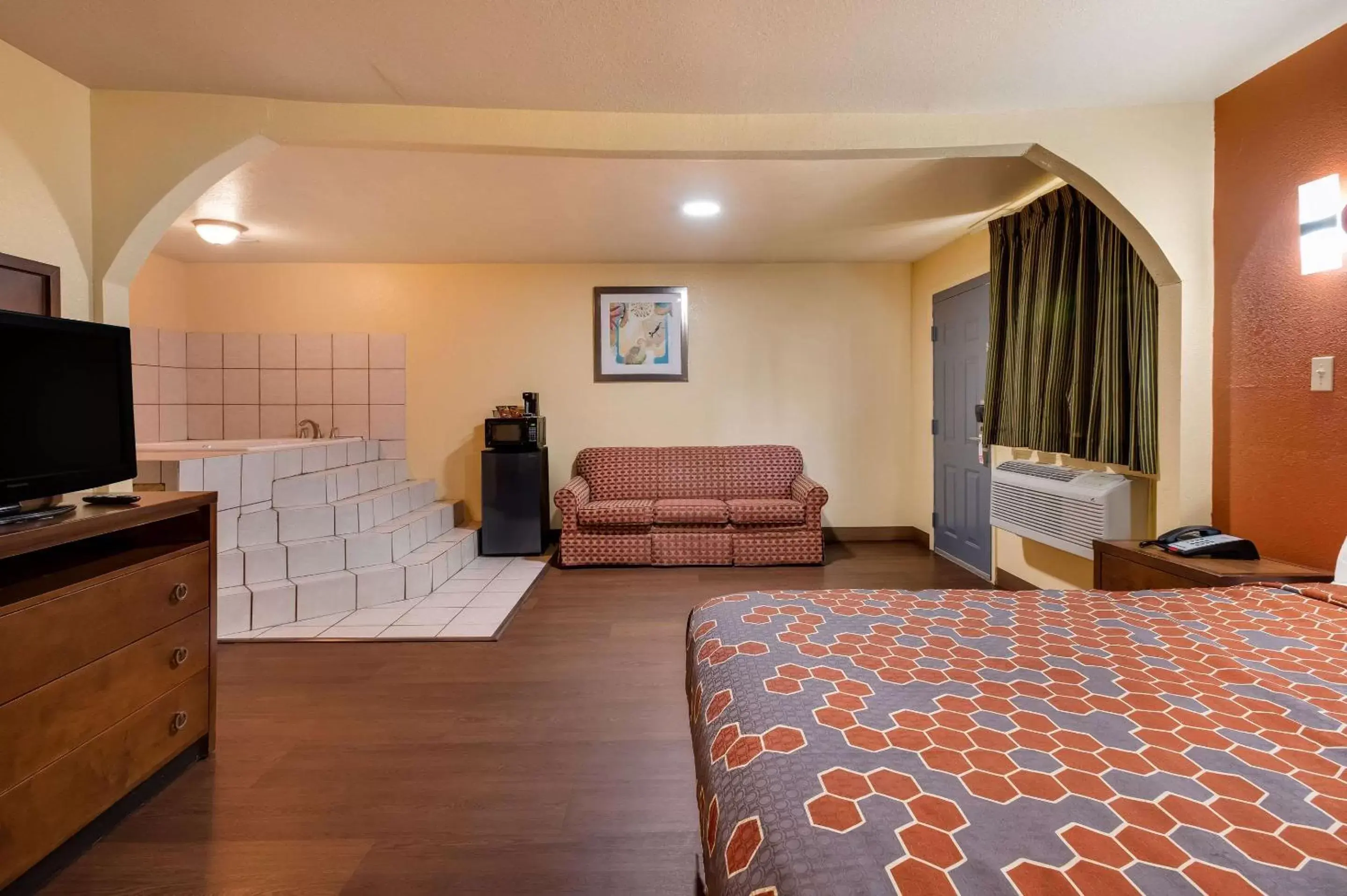 Bedroom, Seating Area in Rodeway Inn & Suites East