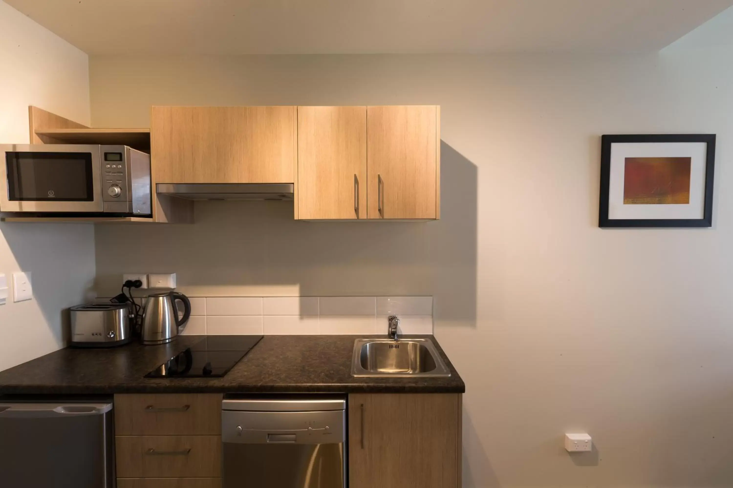 Living room, Kitchen/Kitchenette in Ramada Suites by Wyndham Christchurch City
