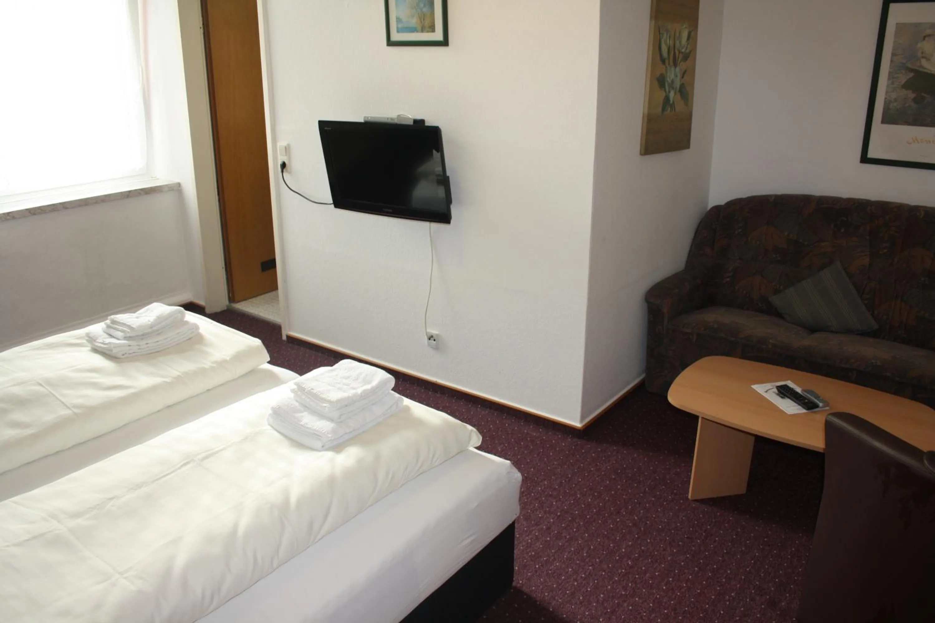 Communal lounge/ TV room, Bed in Hotel Am Kamin
